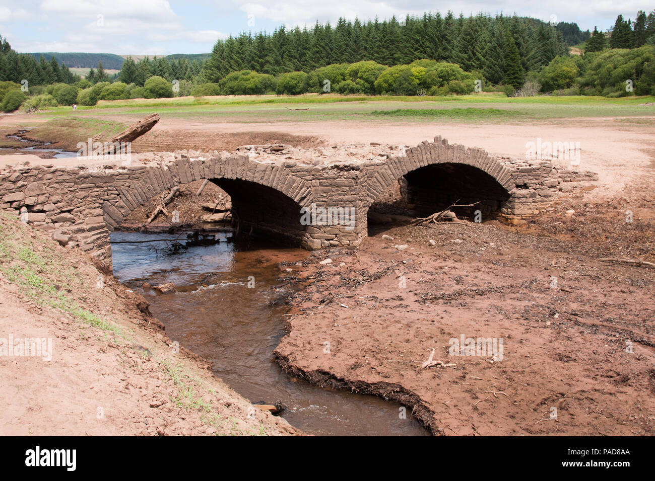 Llwyn Onn serbatoio, Merthyr Tydfil, South Wales, Regno Unito. 22 luglio 2018. Meteo REGNO UNITO: L'ondata di caldo ha causato questo serbatoio per diventare fortemente impoverita con la linea d'acqua ben al di sotto del normale. Un ruscello che scorre nel serbatoio è seccato. Pont Yr Daf bridge, un vecchio ponte in uso prima che il serbatoio per la costruzione, ora di solito subacquea, è stato scoperto a. Credito: Andrew Bartlett/Alamy Live News Foto Stock