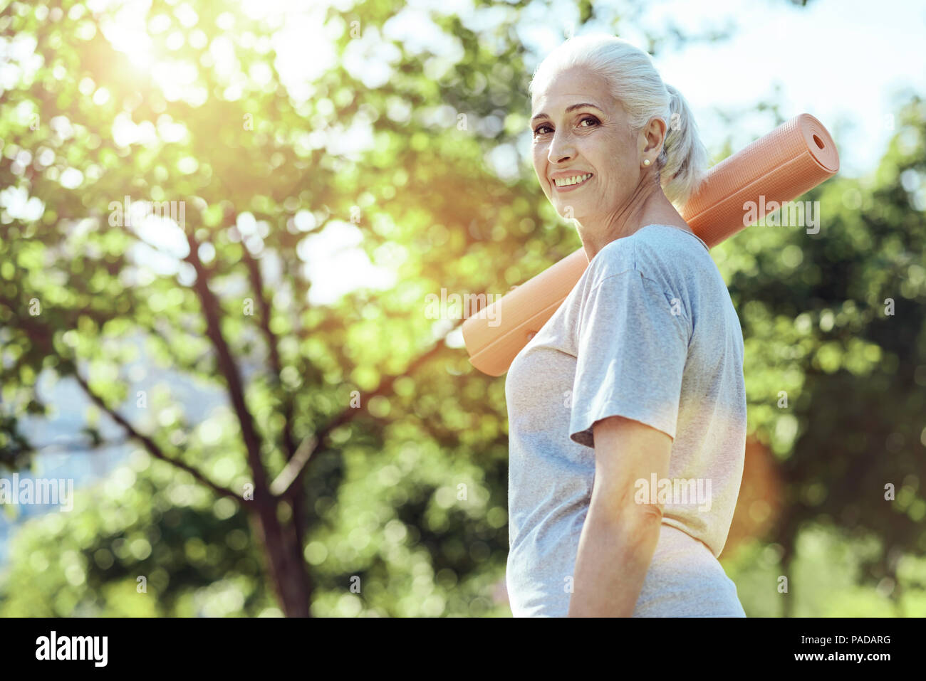 Rilassata vecchia donna di trascorrere del tempo in un parco Foto Stock