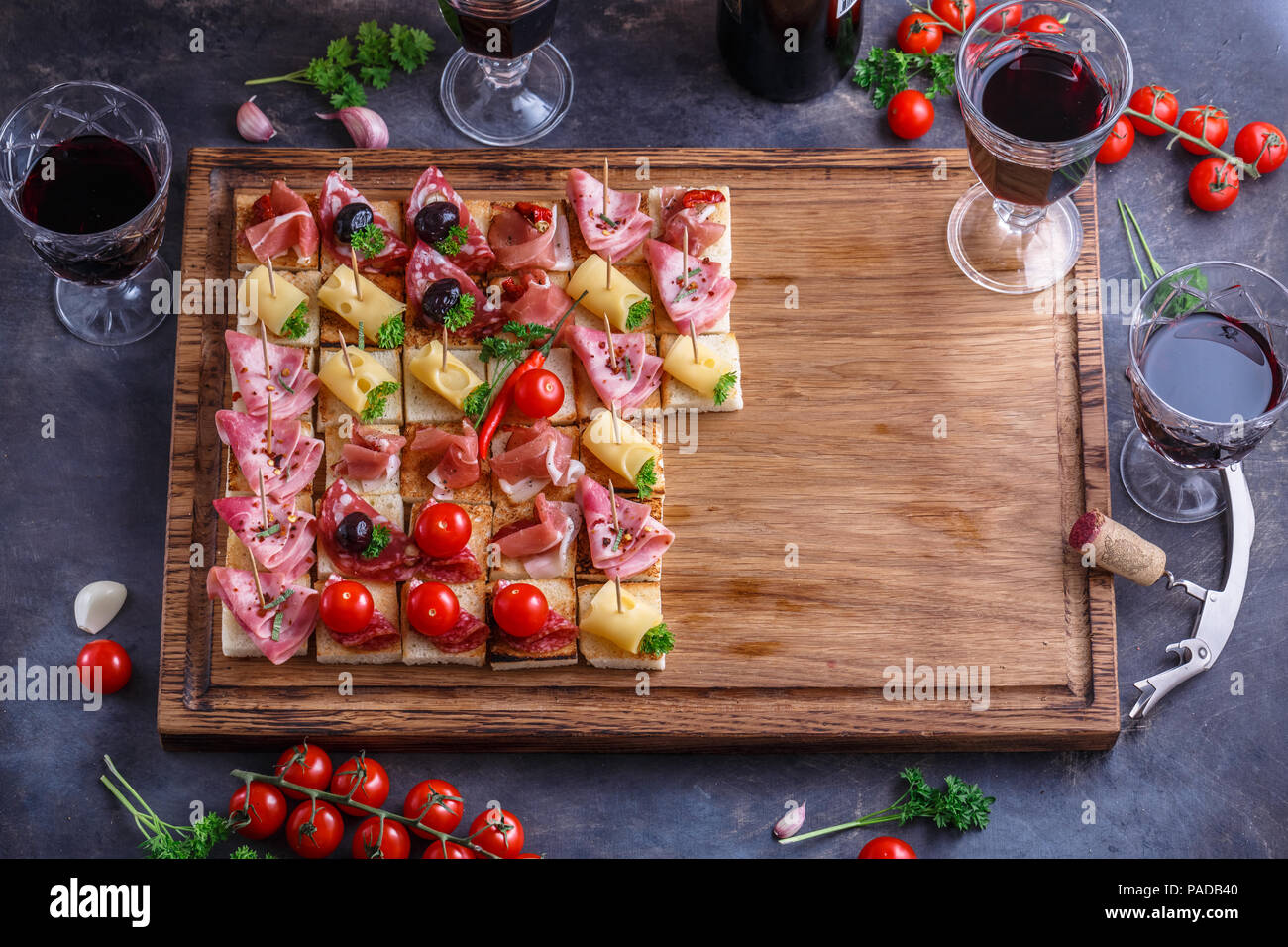 Spaghetti o autentici tradizionali tapas spagnole impostato per tavola da pranzo. Antipasti di condivisione su un partito o picnic estivo tempo blu su sfondo rustico. Vista superiore, piatto laici. Foto Stock