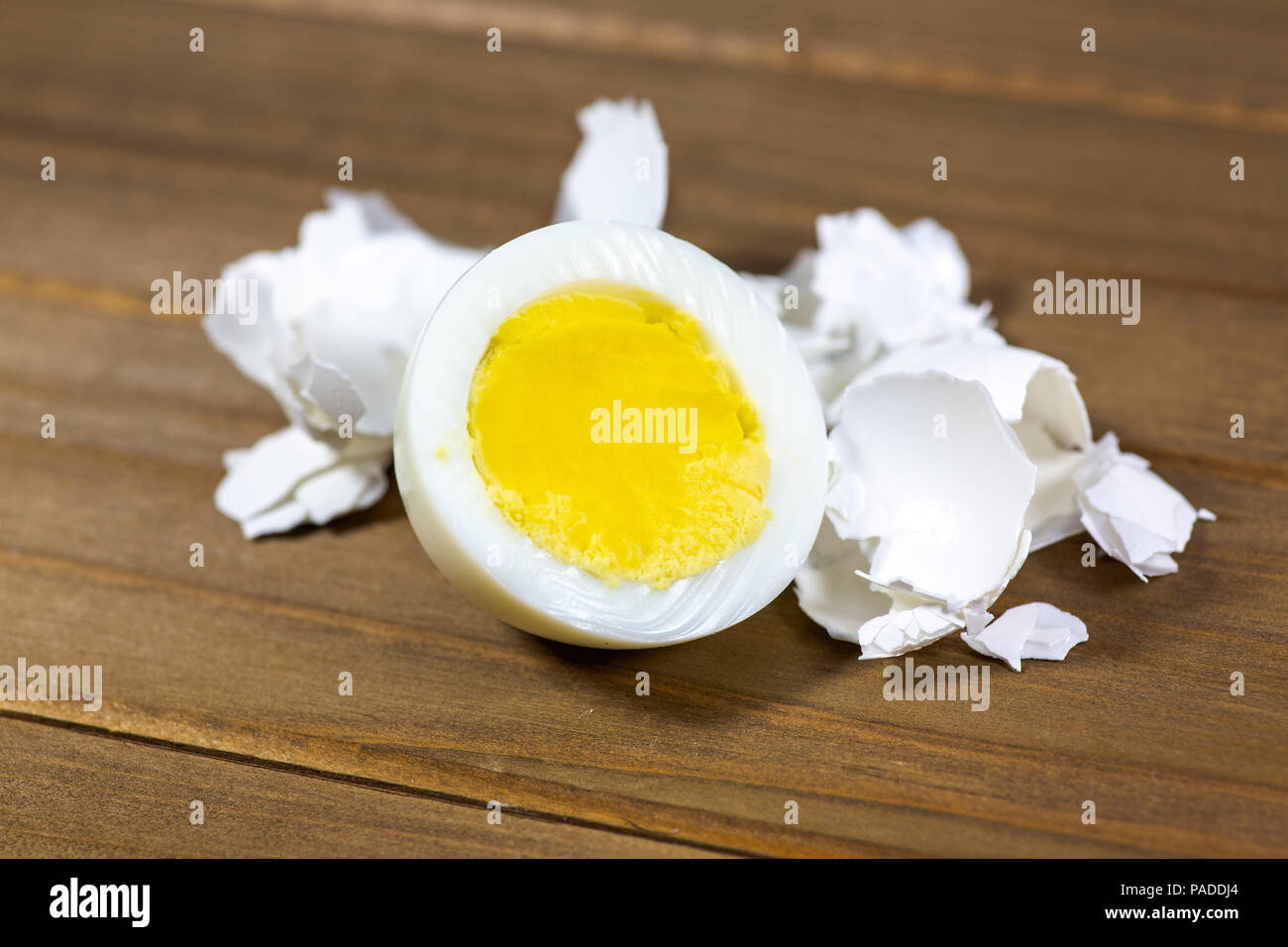 La metà di una uova sode con i gusci posa sul tavolo della cucina Foto Stock