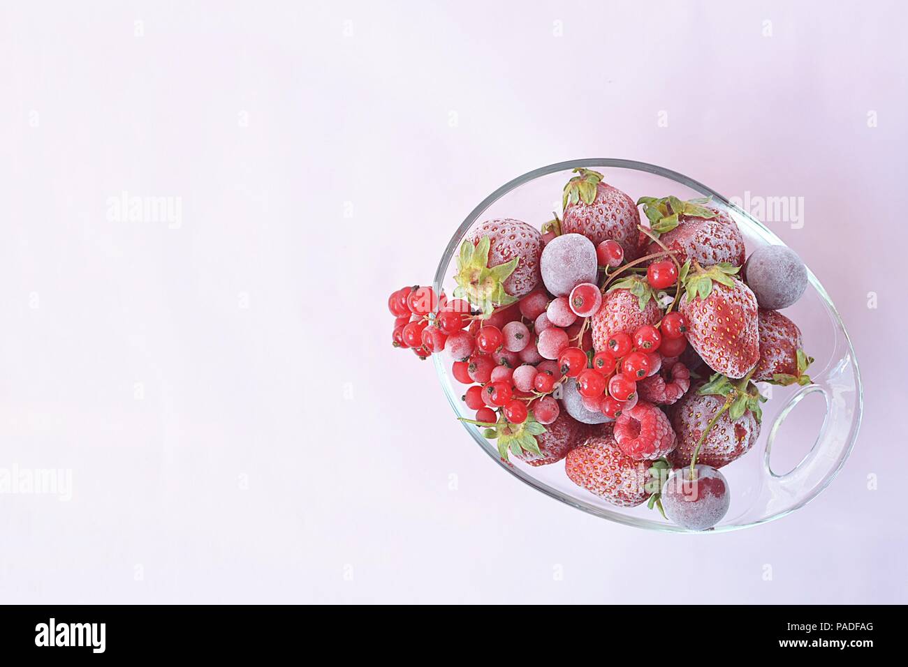 Vaso di vetro pieno di surgelati di frutta rossa Foto Stock