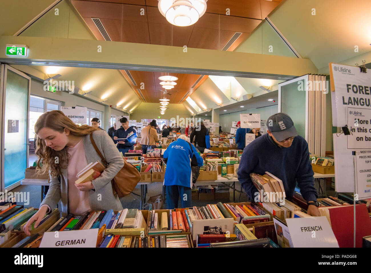 Persone che setacciano i libri in una raccolta fondi per la fiera Lifeline del libro presso la Knox Grammar School di Wahroonga, New South Wales, Australia Foto Stock