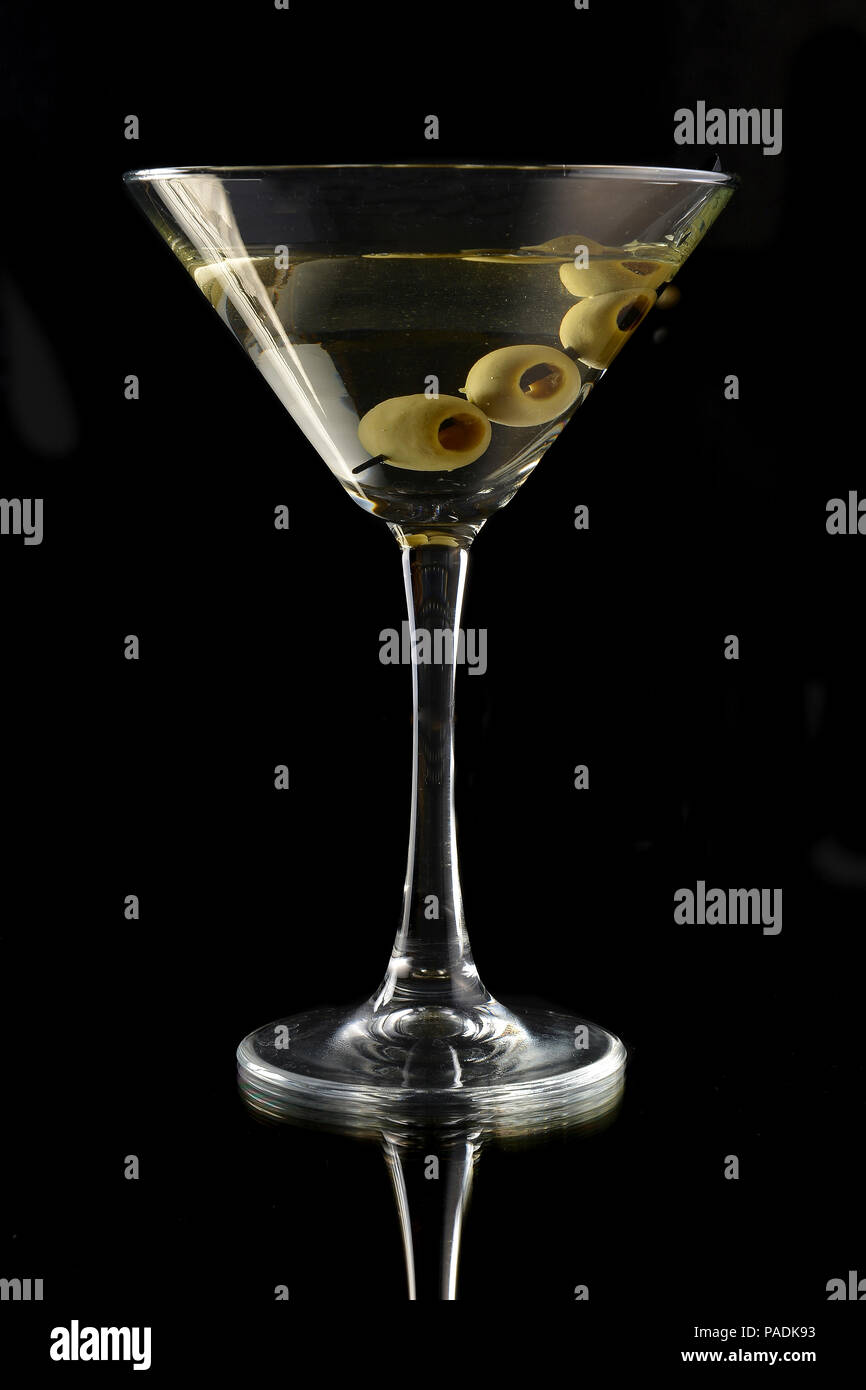 Martini con olive nere su sfondo nero Foto Stock