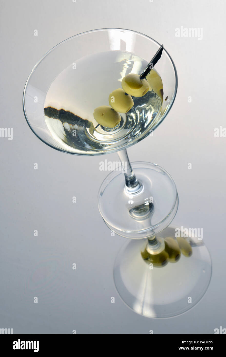 Martini con olive nere su sfondo chiaro Foto Stock