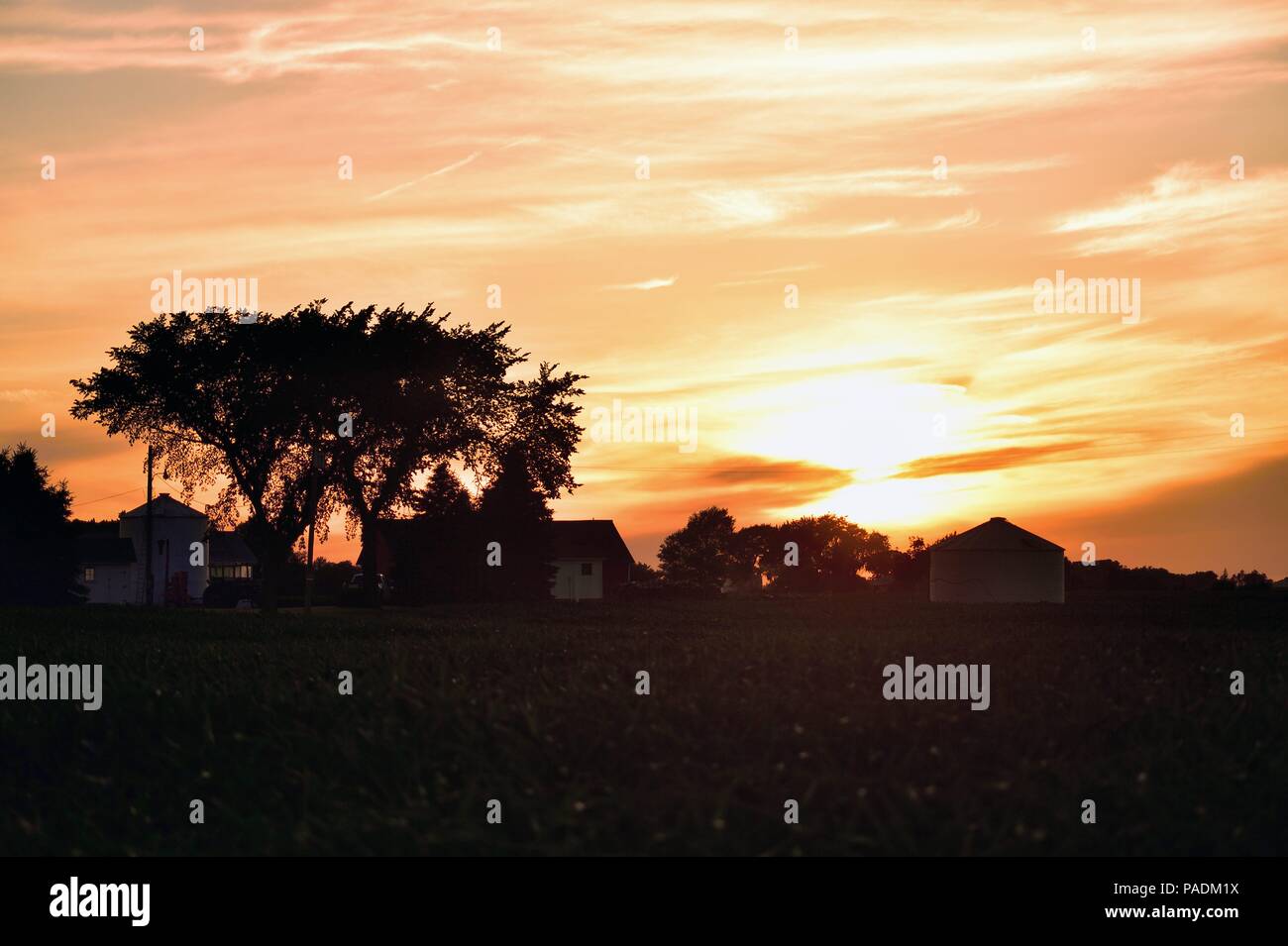 Burlington,, Illinois, Stati Uniti d'America. Il sole tramonta al di là di una fattoria in northerastern Illinois. Foto Stock