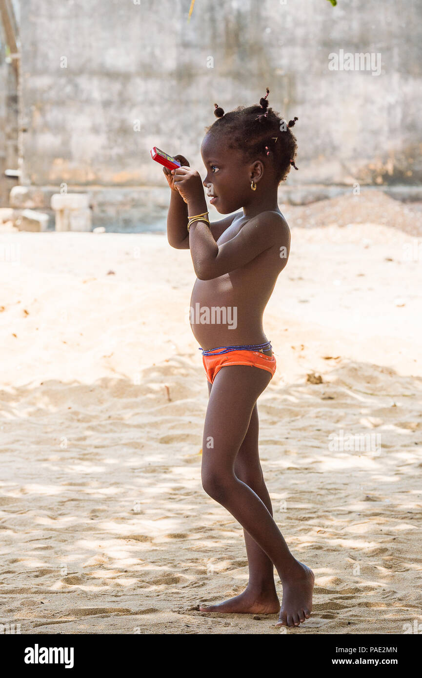 KARA, TOGO - Mar 10, 2013: togolesi non identificato bambina in rosso delle mutande ritratto. I bambini in Togo soffrono di povertà a causa della instabilità econim Foto Stock