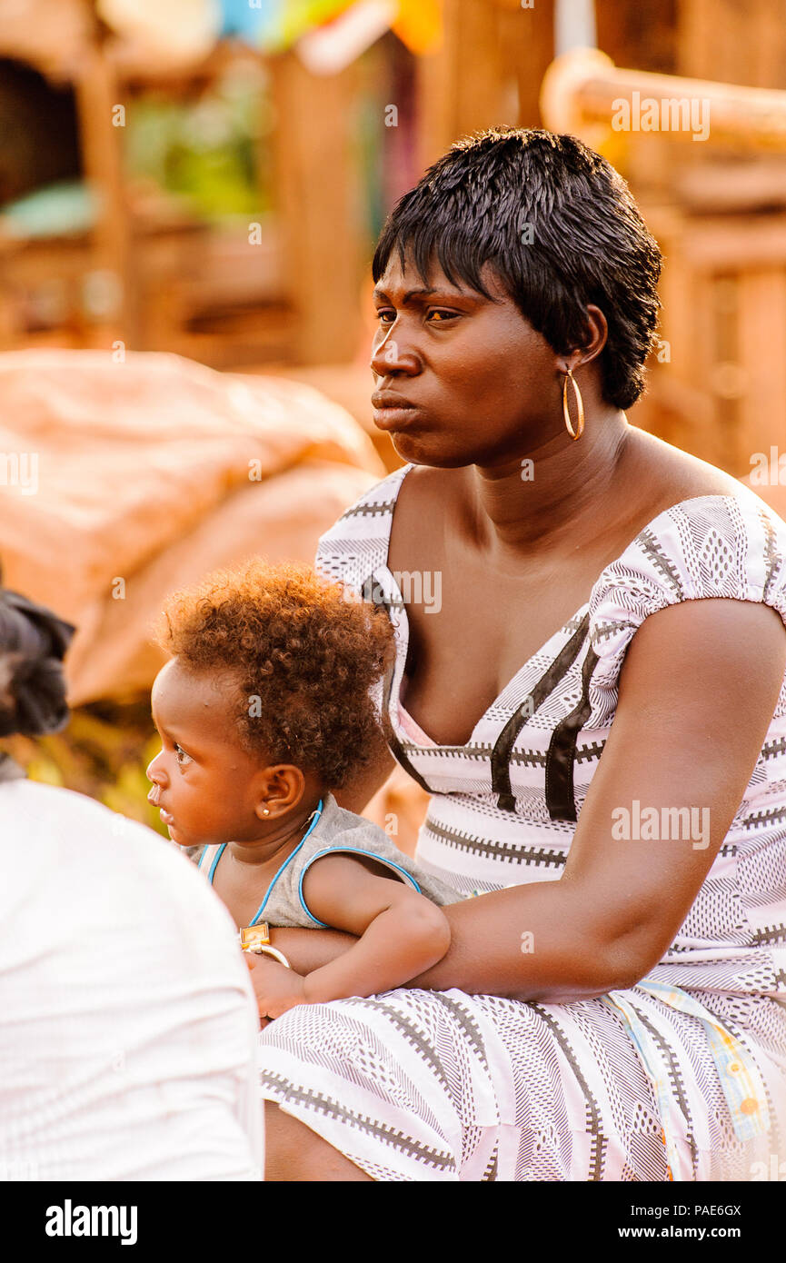 ACCRA, GHANA - Marzo 5, 2012: Unidentified ghanesi baby boy sulla sua madre giro in strada in Ghana. I bambini del Ghana soffrono di povertà a causa della Foto Stock