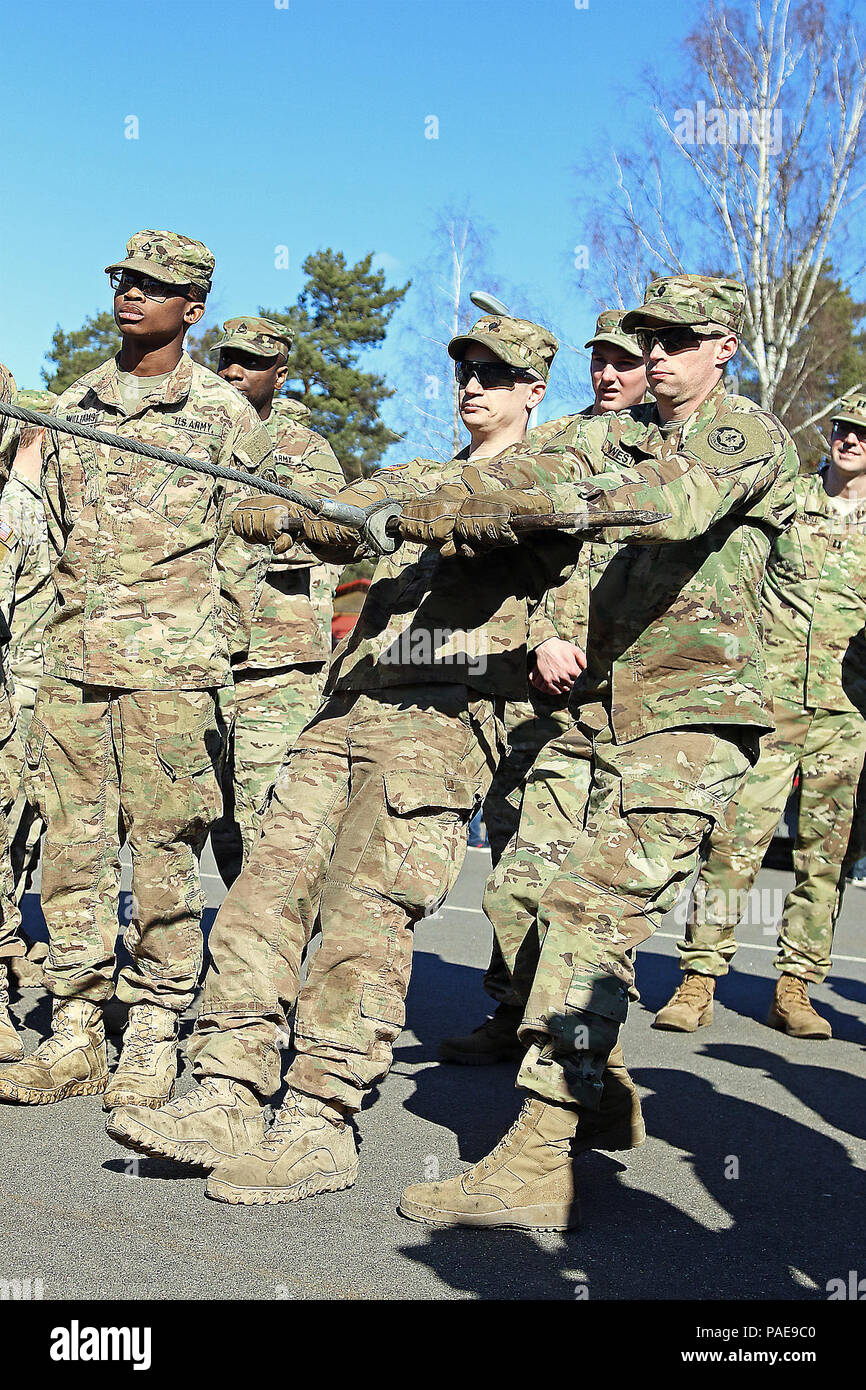Spc. Scott Johnson (centro), e SPC. Wesley Westfall (a destra), entrambe le ruote meccanica del veicolo assegnato alla sede centrale e sede di truppe, 3° Stormo, 2° reggimento di cavalleria, dimostrare il funzionamento sicuro procedura di auto-recupero argani per Stryker Armored veicoli da combattimento durante un cavalletto di sicurezza verso il basso, 24 Marzo a Adazi Base Militare, Lettonia. Wolfpack soldati ha ricevuto istruzioni di revisione e una dimostrazione, garantire che essi abbiano familiarità con il corretto e sicuro funzionamento del verricello per evitare gli incidenti mentre in Lettonia la formazione a sostegno del funzionamento Atlantic risolvere, una multinazionale demonstrat Foto Stock