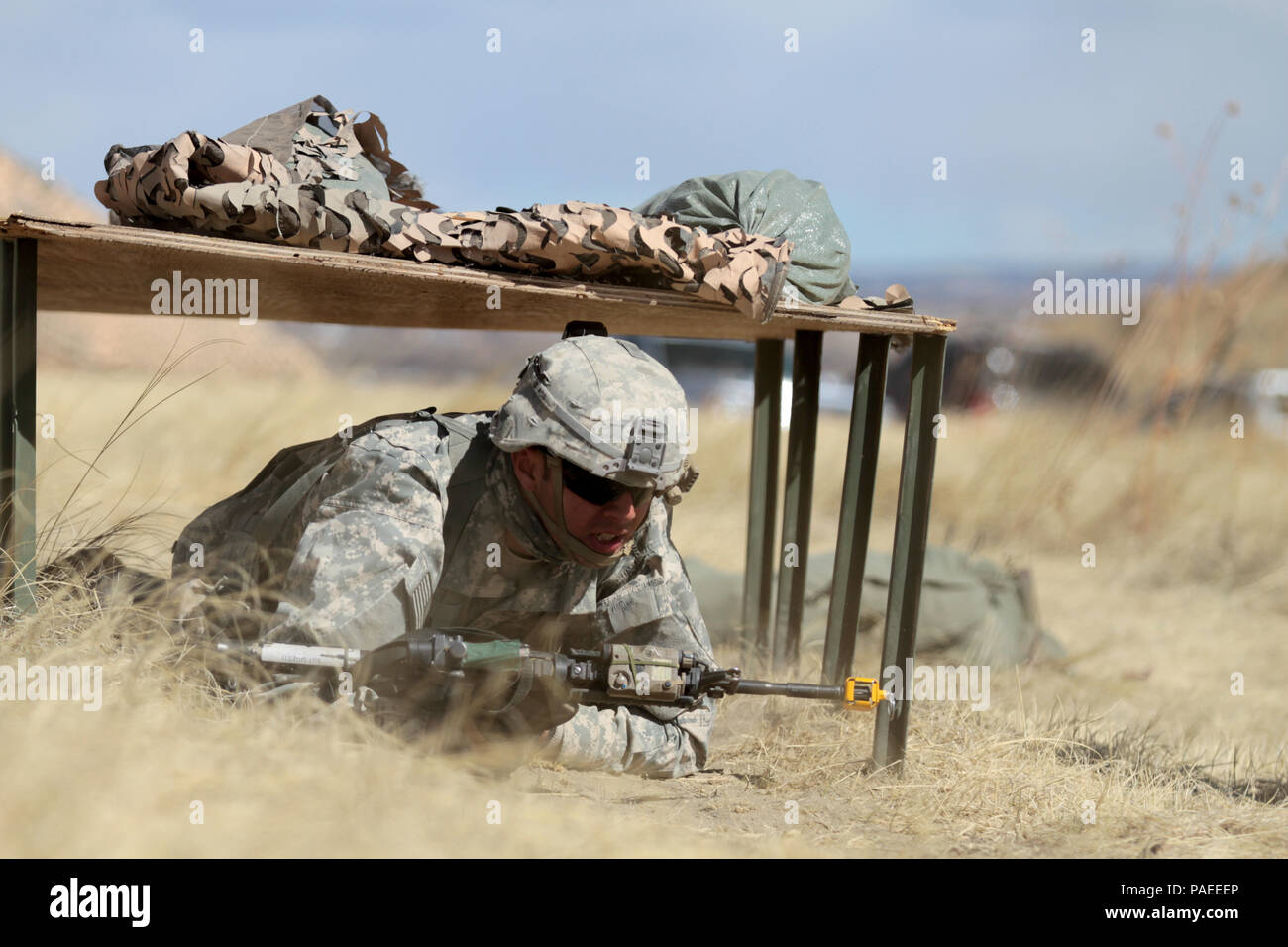 Il personale Sgt. Angelo Sigetti, squadra di fanteria leader, sede e Sede Società, 1° Battaglione, 38th Reggimento di Fanteria, 1° Stryker Brigade Combat Team, 4a divisione di fanteria, si muove sotto simulato fuoco diretto durante il fante esperto valutazioni Badge il 15 marzo 2016. Egli era tenuto a bassa e alta crawl 50 metri prima della volata 100 metri a un nemico posizione in meno di cinque minuti. Foto Stock