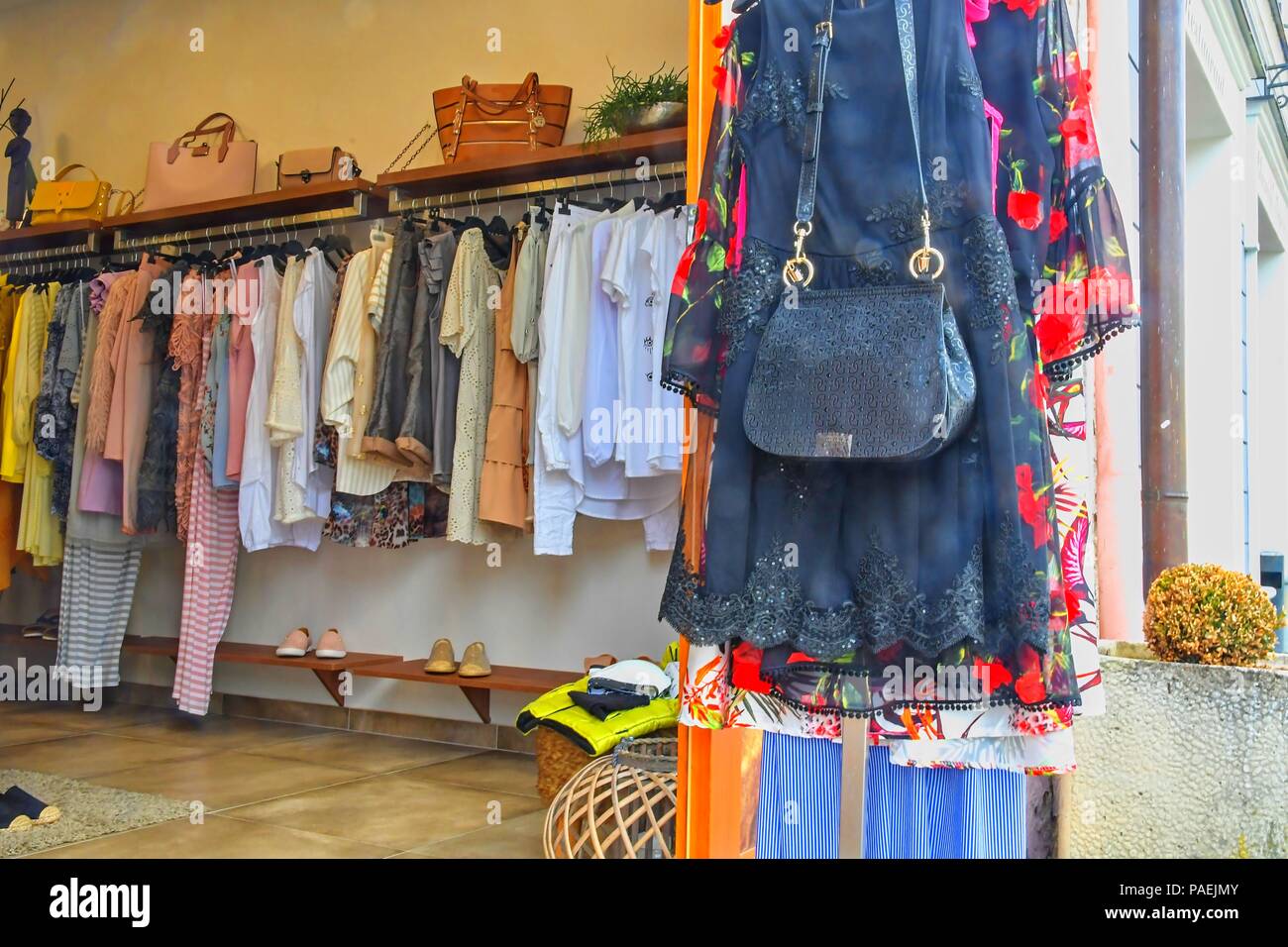 Abiti alla moda in un negozio boutique. Abbigliamento su hanger presso il negozio moderno boutique. Messa a fuoco selettiva. Foto Stock