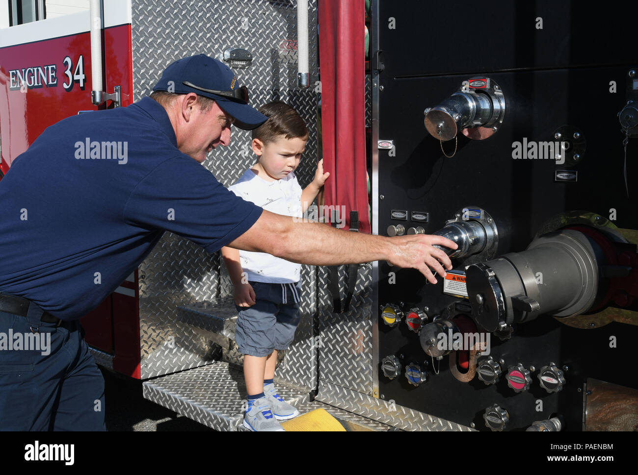 Guy Chadwick, 81st Divisione Infrastruttura pompiere, mostra parti di un firetruck a Peter Walker, figlio del Magg. Sam Walker, 81st Operations Support Commander di volo, durante un incendio prevenzione settimana dimostrazione presso il bambino Keesler Centro di sviluppo 11 ott. 2017, su Keesler Air Force Base, Mississippi. L'evento della durata di una settimana incluse le esercitazioni antincendio, letteratura dispense, stufa dimostrazioni di fuoco intorno alla base e ha concluso con un open house presso il dipartimento dei vigili del fuoco. (U.S. Air Force foto di Kemberly Groue) Foto Stock