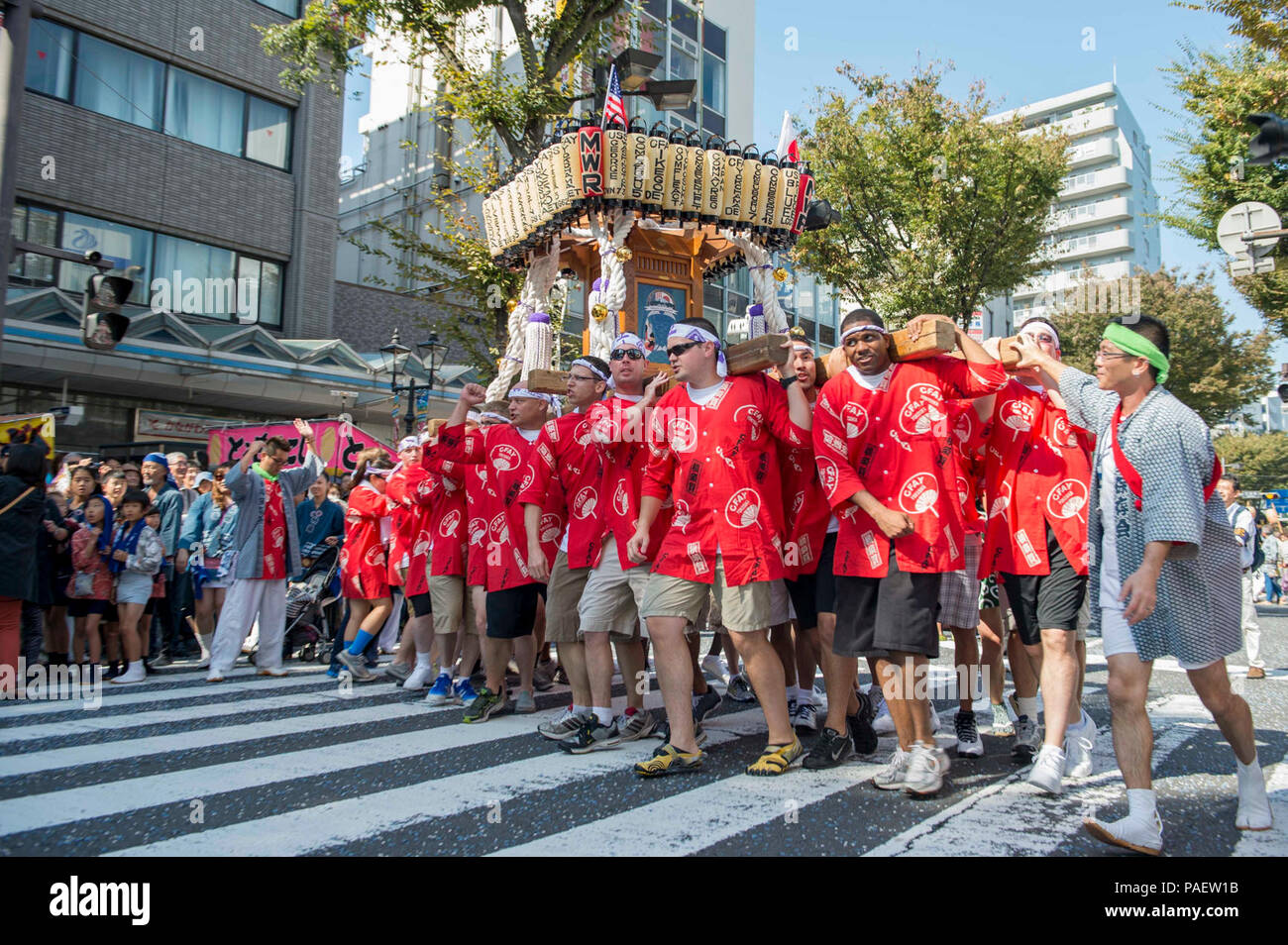 Marinai e civili di partecipanti provenienti da attività della flotta Yokosuka portano un giapponese mikoshi durante la trentottesima Yokosuka annuale parata Mikoshi. In giapponese lo Shintoismo tradizione buddista Mikoshi sono portatili santuari in miniatura utilizzati per trasportare lo spirito di una divinità. La parata passa attraverso il centro di Yokosuka e termina sulla attività della flotta Yokosuka. Foto Stock