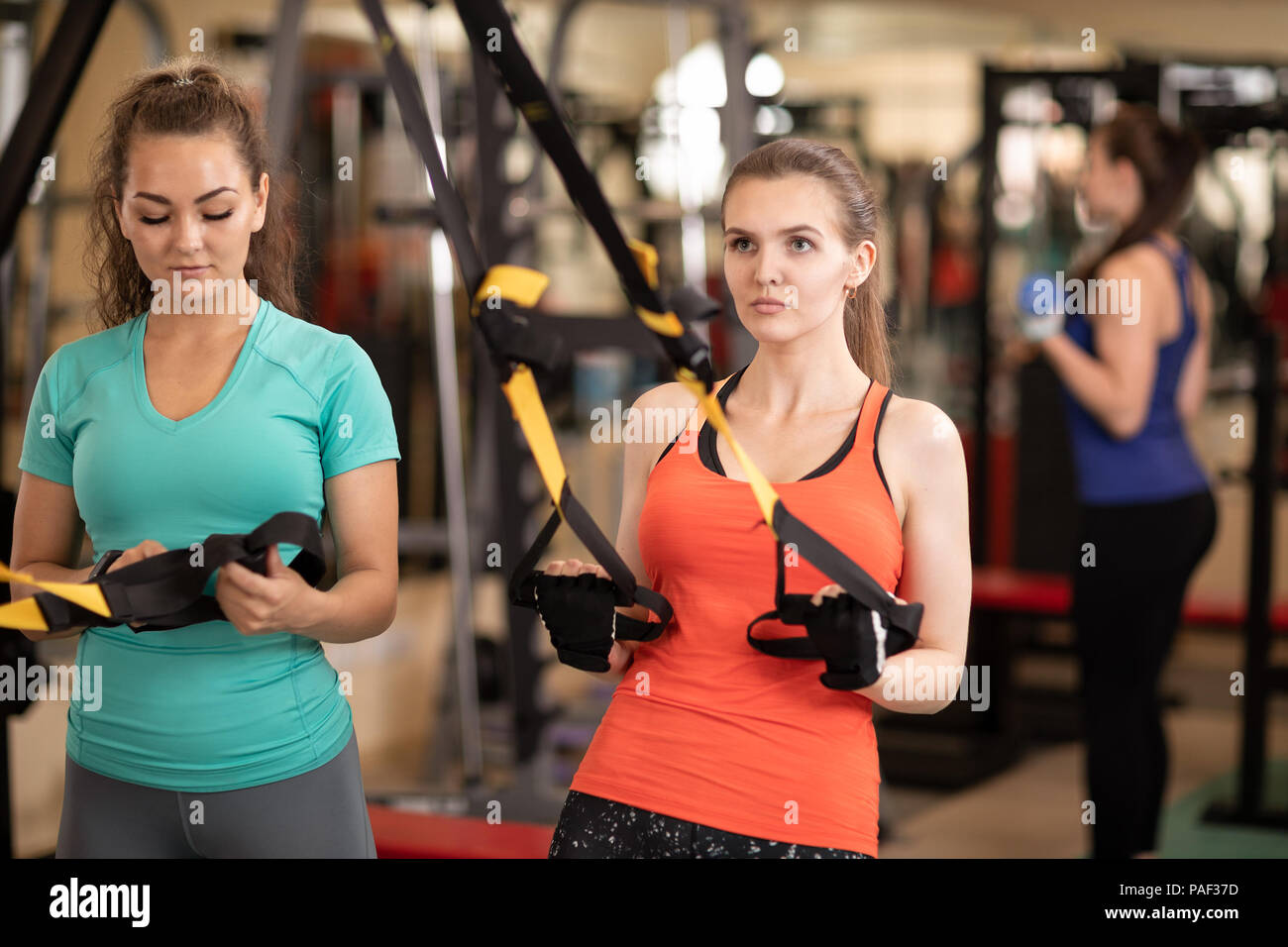 Womans rendendo trx palestra fitness in palestra Foto Stock