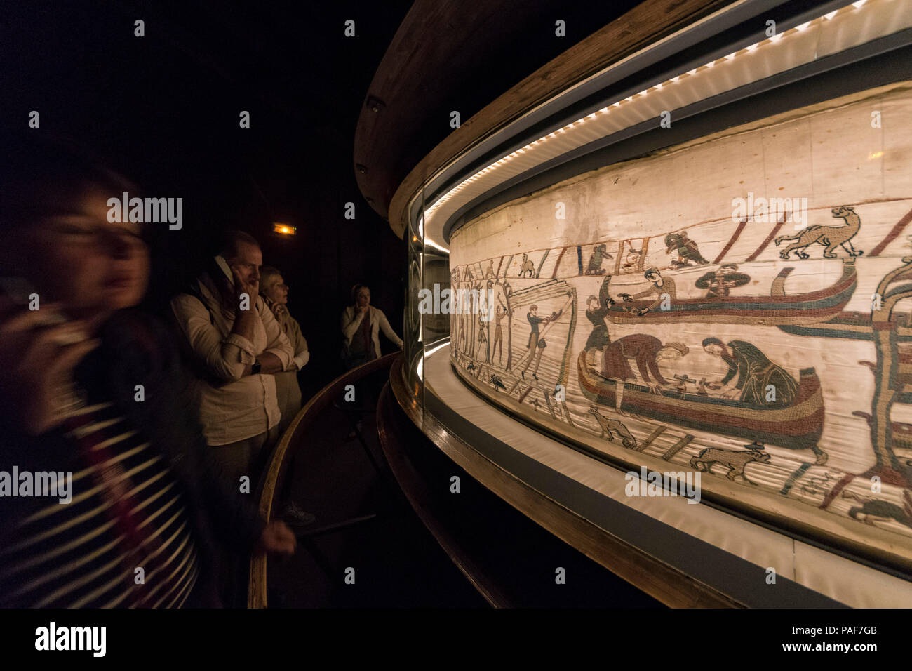 Bayeux, Francia. Visitorswalk passato il famoso arazzo (Tapisserie) di Bayeux,1000 anno moquette vecchia che racconta la storia della conquista normanna di Inghilterra Foto Stock