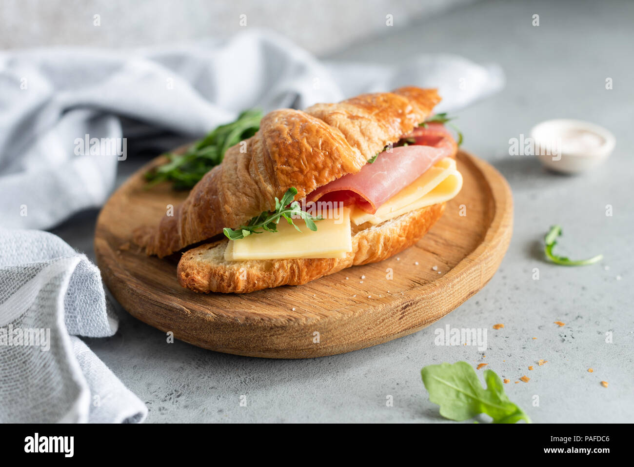 Sandwich con prosciutto e formaggio su brioche bun. Croissant gustosi sandwich. Messa a fuoco selettiva Foto Stock