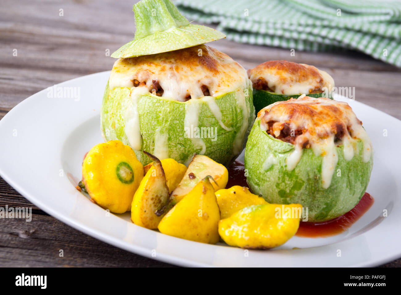 Round zucchine ripiene sfera con la quinoa e formaggio servita con arrosti di Patty pan squash Foto Stock