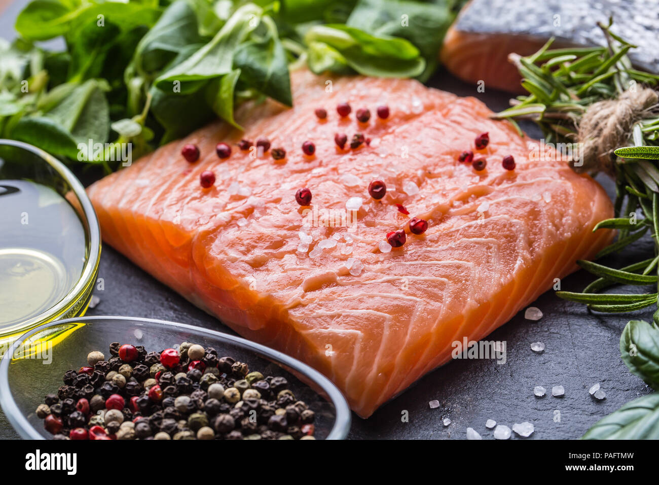 Materie filetto di salmone con rosmarino basilico olio di oliva sale e pepe. Foto Stock