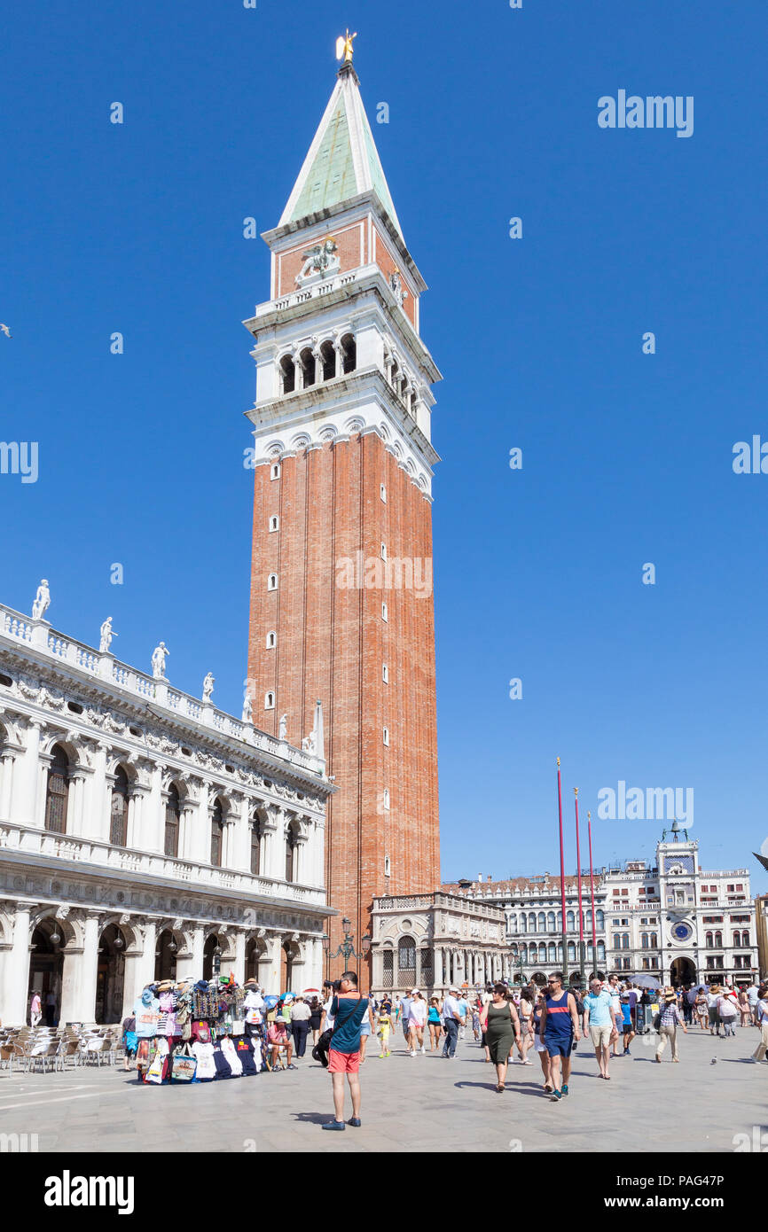 Campanile o torre campanaria di St Marks Cattedrale, Piazza San Marco, San Marco, Venezia, Veneto, Italia con turisti contro un cielo blu Foto Stock