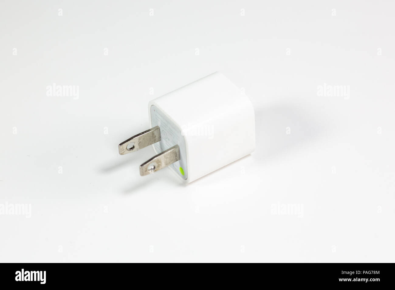Un telefono USB e caricabatterie per il dispositivo su un tavolo bianco Foto Stock