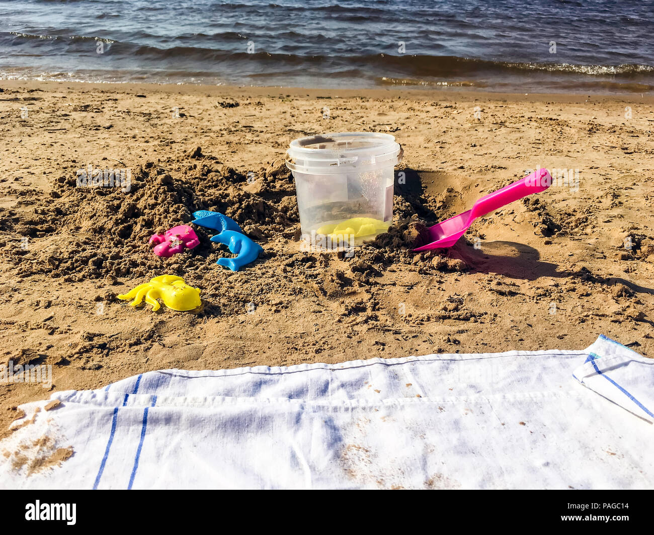 Plastica forme colorate, cazzuola e piccolo cucchiaio per giocare i bambini  con la sabbia sulla spiaggia. Baby stampi di plastica che giace nella sabbia  sul seabeach. Luminose Foto stock - Alamy