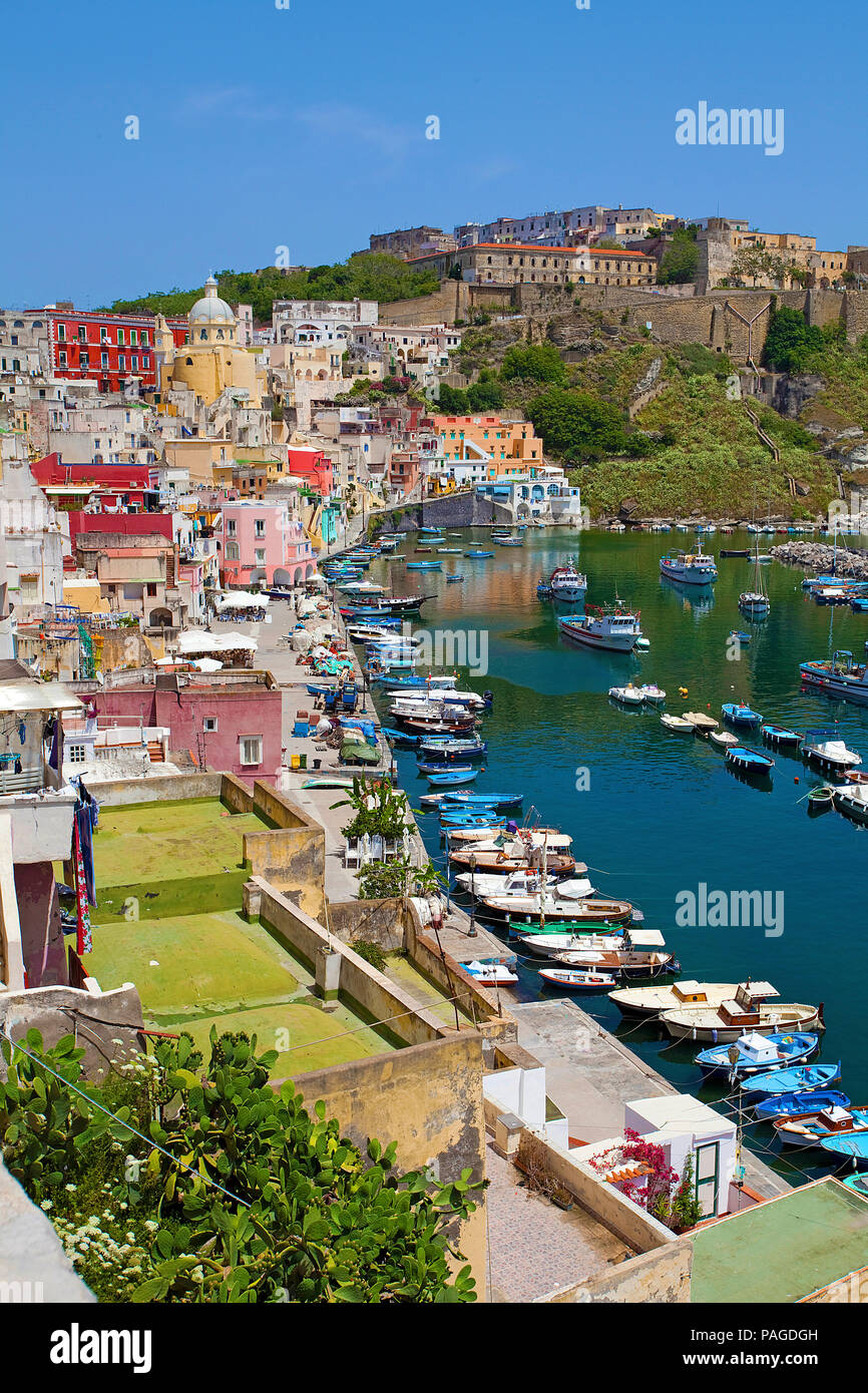 Il villaggio di pescatori di Procida con il porto di pescatori di Marina di Corricella e fortezza di Terra Murata, un ex carcere, Golfo di Napoli, Italia Foto Stock