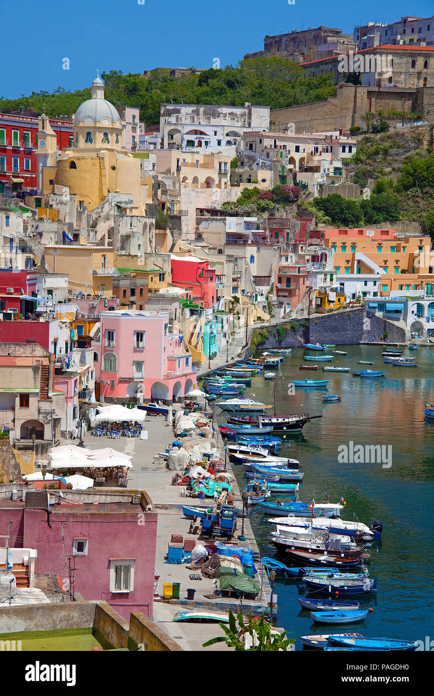 L'idilliaco villaggio di pescatori Procida con il porto di pescatori di Marina di Corricella e fortezza di Terra Murata, un ex carcere, Golfo di Napoli, Italia Foto Stock