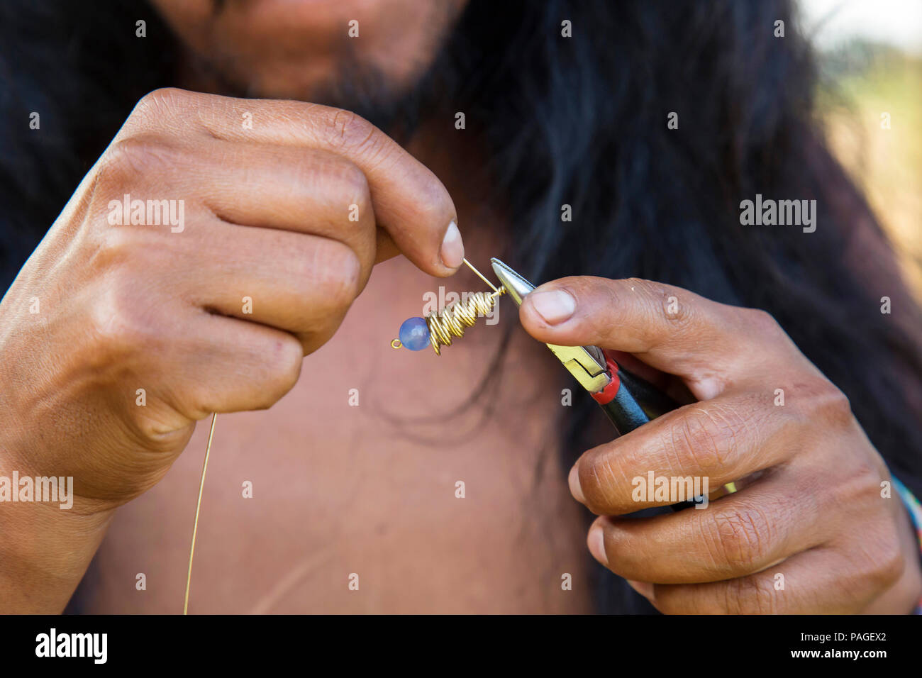 Creatore di gioielli mani creazione di orecchini in ottone stringa di metallo Foto Stock