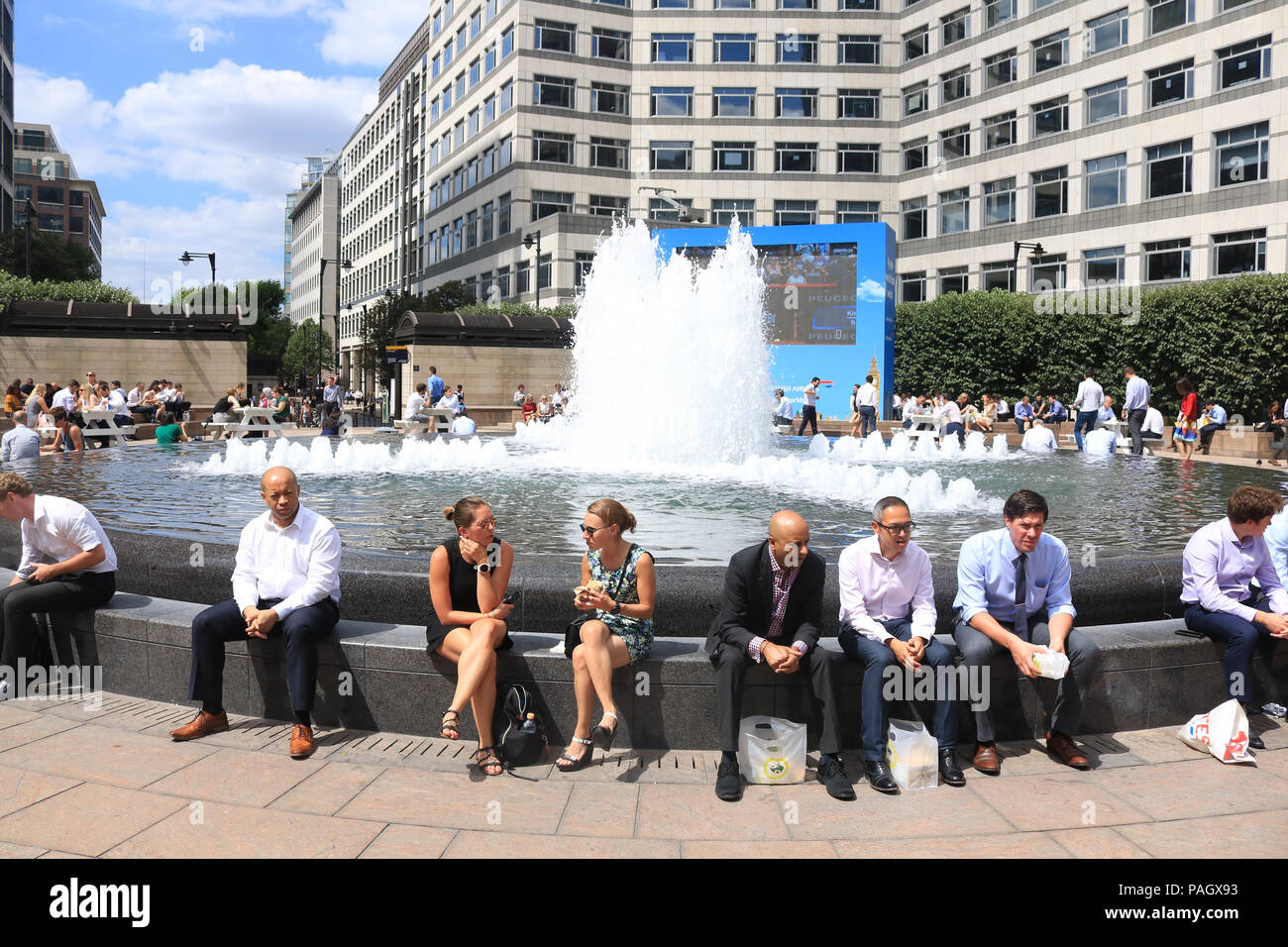 Londra. Regno Unito. Il 23 luglio 2018. Città i lavoratori godono di loro lunchbreak in estate il sole in Cabot Square, canry Wharf con temperature attese per raggiungere 35C di questa settimana e la Met Office emette un Ambra avviso meteo per le parti della Gran Bretagna colpita dall'attuale ondata di caldo Credito: amer ghazzal/Alamy Live News Foto Stock