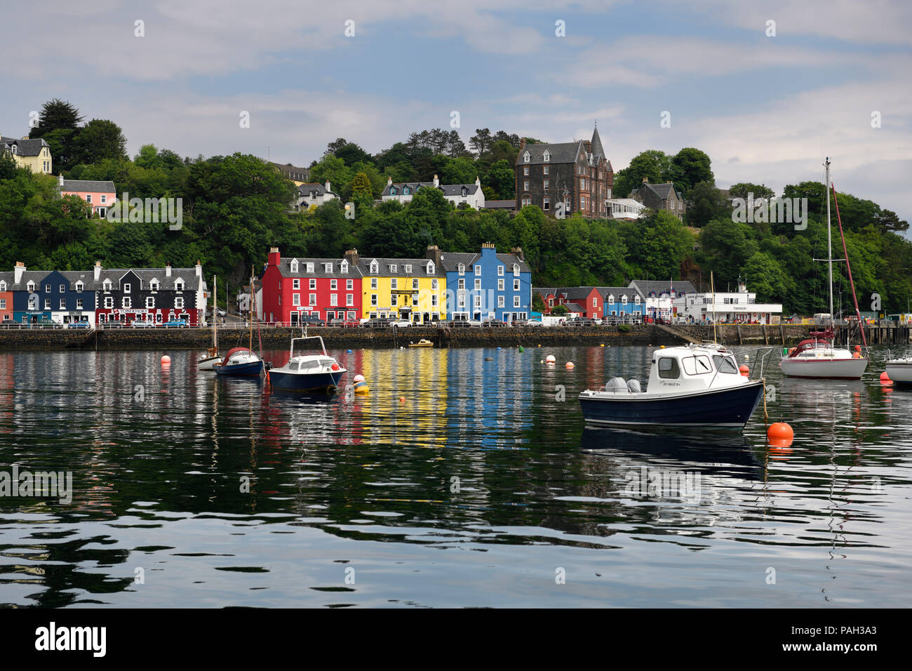 Case colorate si riflette nell'acqua di Tobermory Harbour per il Isle of Mull con barche ormeggiate scozzesi Ebridi Interne in Scozia UK Foto Stock