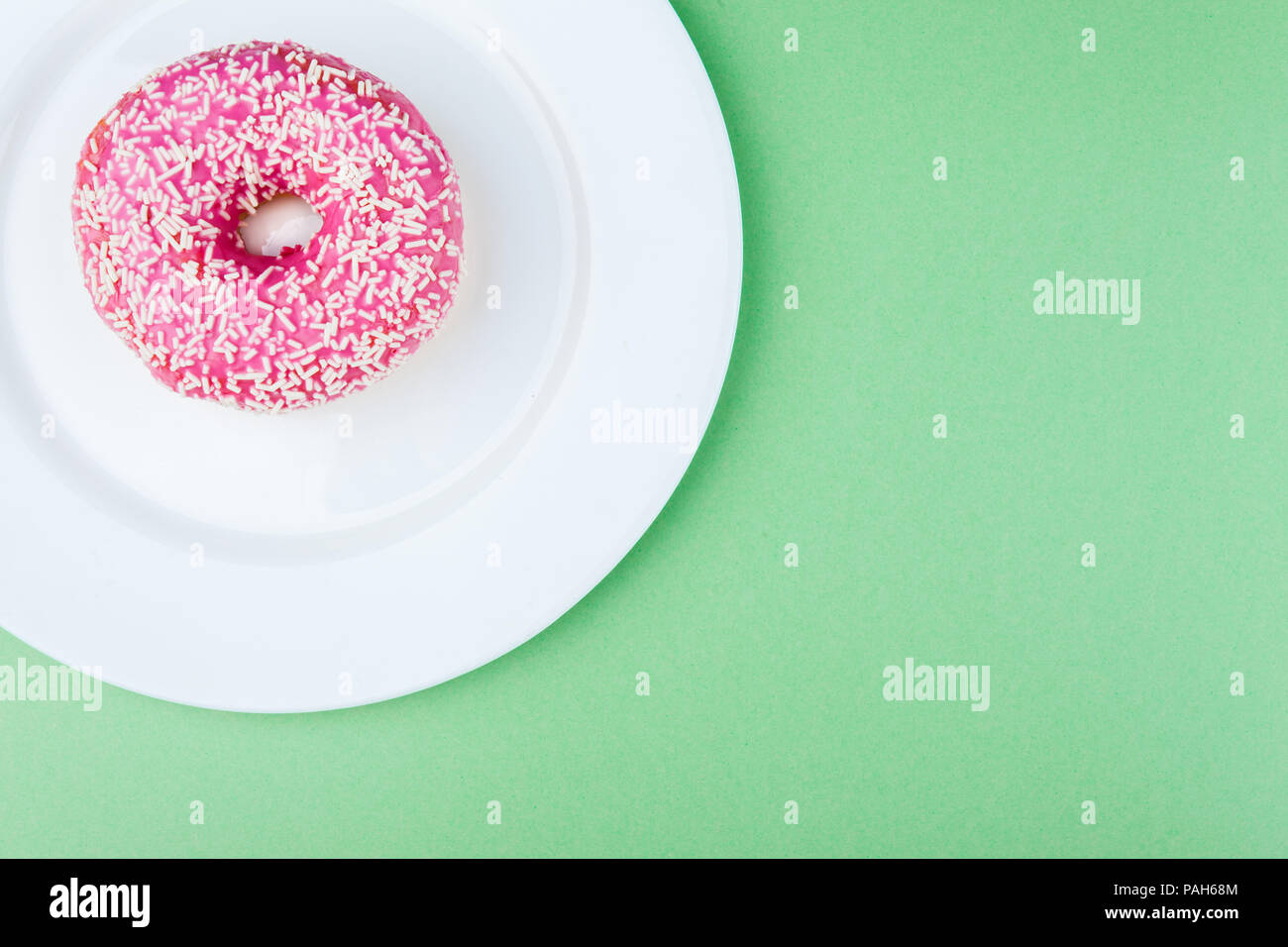 Rosa ciambella vetrate sul verde sfondo pastello Foto Stock