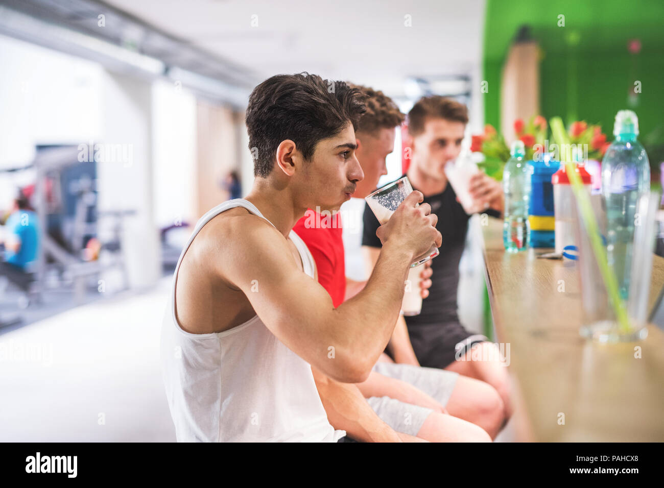 Uomini in palestra seduta e bicchieri di contenimento della bevanda di proteina. Foto Stock