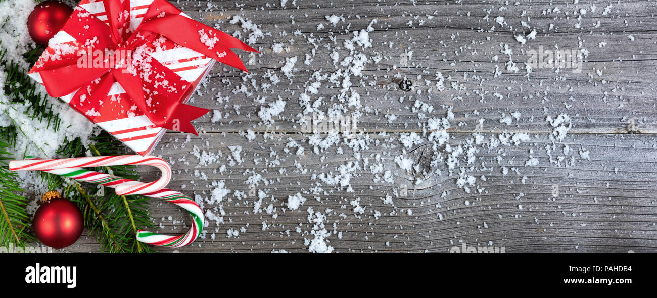 Vista aerea di una coperta di neve regalo di Natale scatola con abete rami sul legno invecchiato per il concetto di vacanza Foto Stock