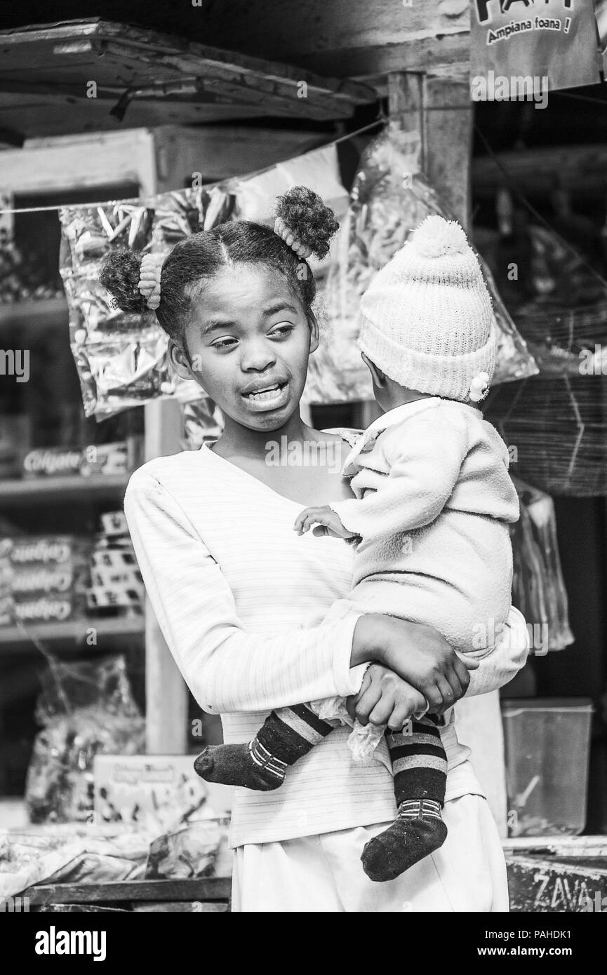 ANTANANARIVO, MADAGASCAR - Giugno 30, 2011: Unidentified Madagascar ragazza abbraccia il suo bambino sulle braccia. Persone in Madagascar soffrono di povertà a causa t Foto Stock