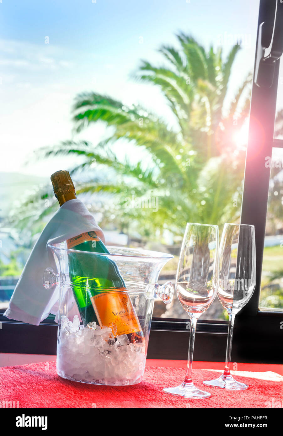 Champagne francese Luxury Hotel Villa Vacanza celebrazione Arrivo Veuve  Clicquot vino spumante raffreddamento sul ghiaccio dalla finestra aperta al  tramonto con esotici vista Palm tree view Foto stock - Alamy