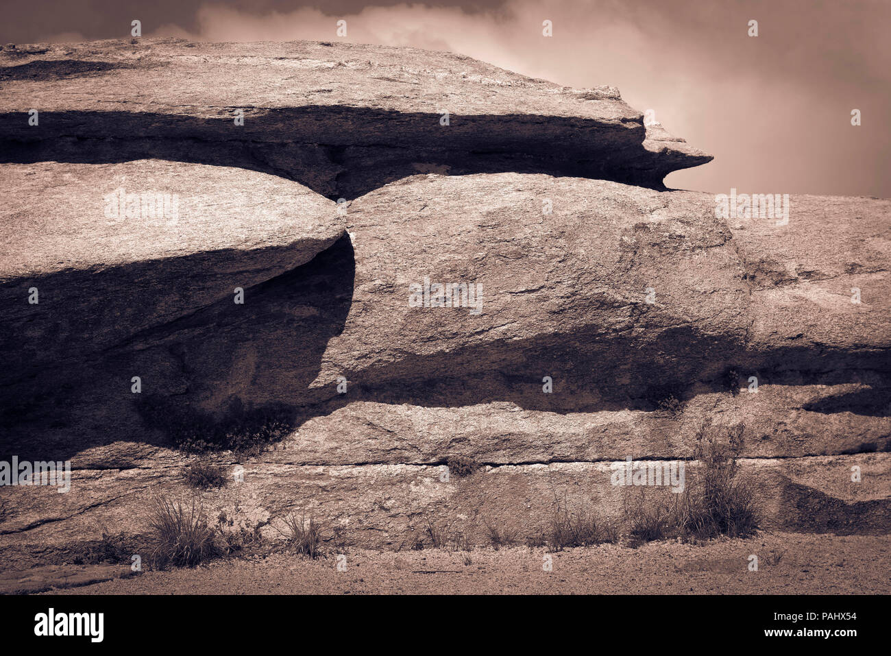 Tonalità seppia Closeup di grandi e unusally appiattita massi di granito appollaiata sul punto di Ventoso vista su Mt. Lemmon nella Foresta Nazionale di Coronado vicino Foto Stock