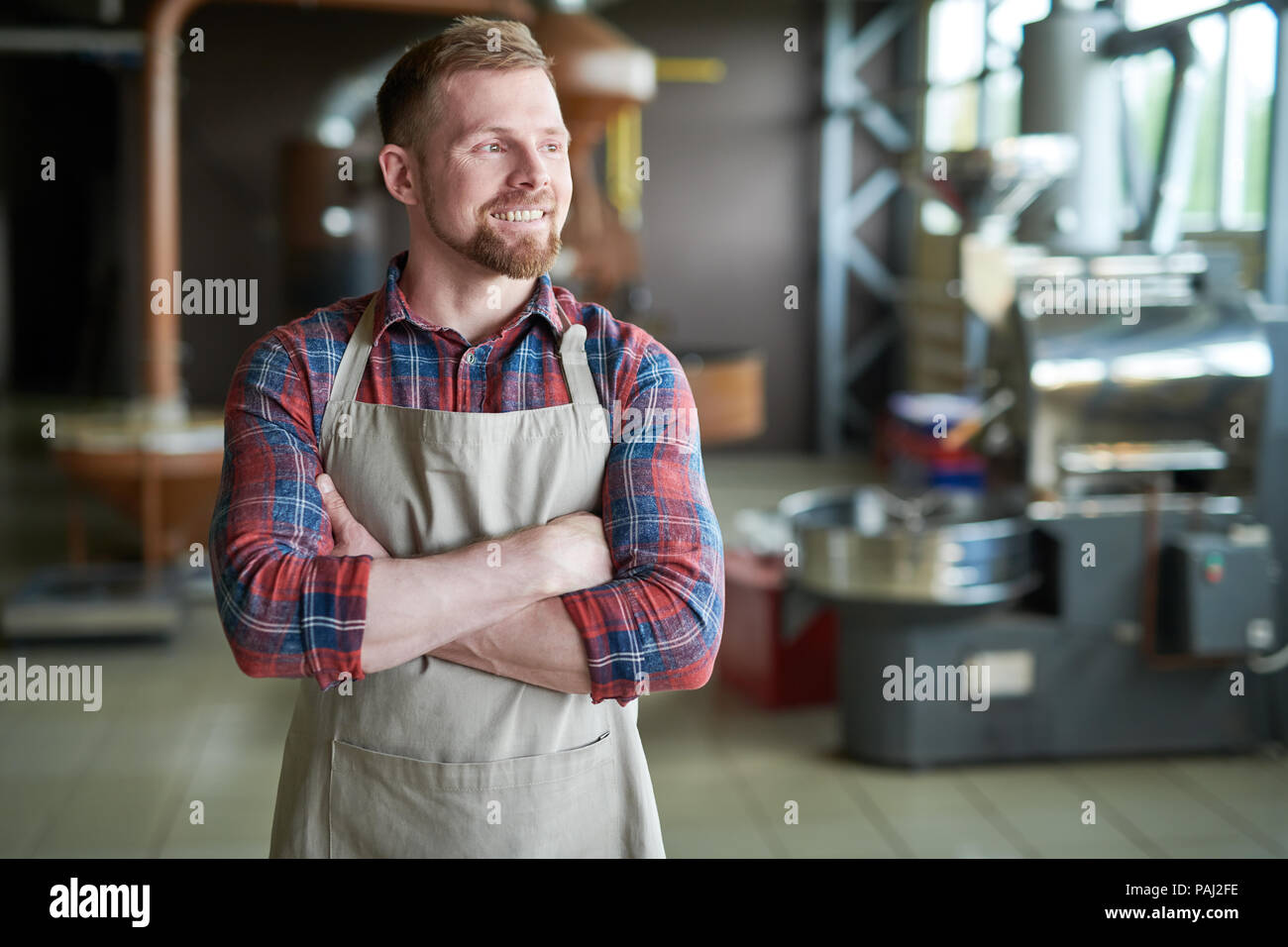 Imprenditore sorridente in posa di caffè Roastery Foto Stock