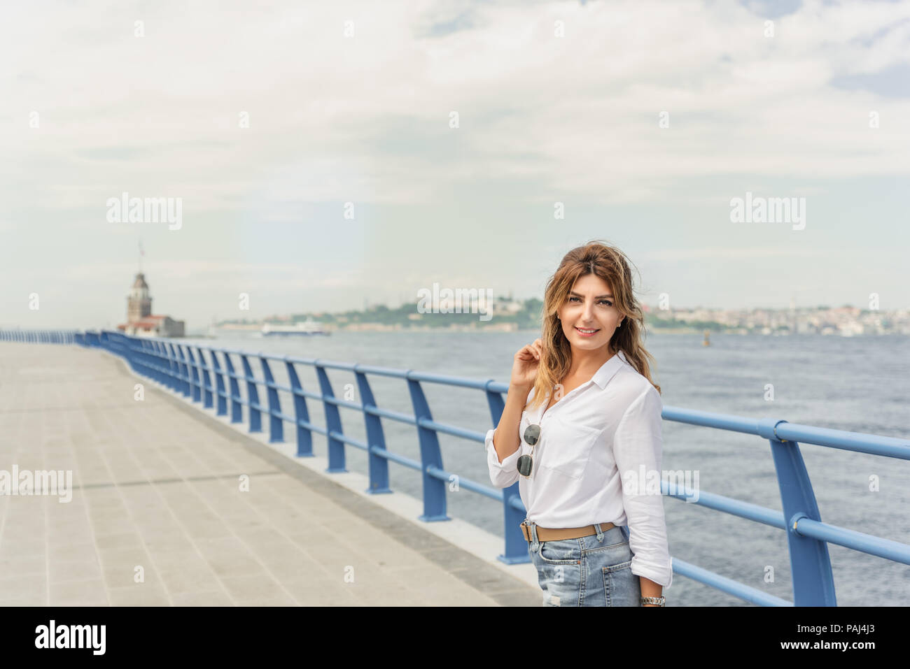 Bella donna traveler è nella parte anteriore dei Maiden Tower,una destinazione popolare di Istanbul, Turchia Foto Stock