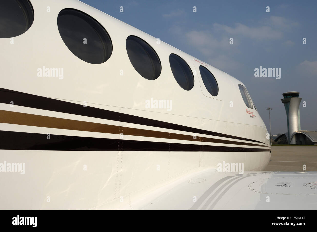 Una Gama Aviation Beechcraft King Air 200 parcheggiato con il controllo del traffico aereo a torre dietro Foto Stock