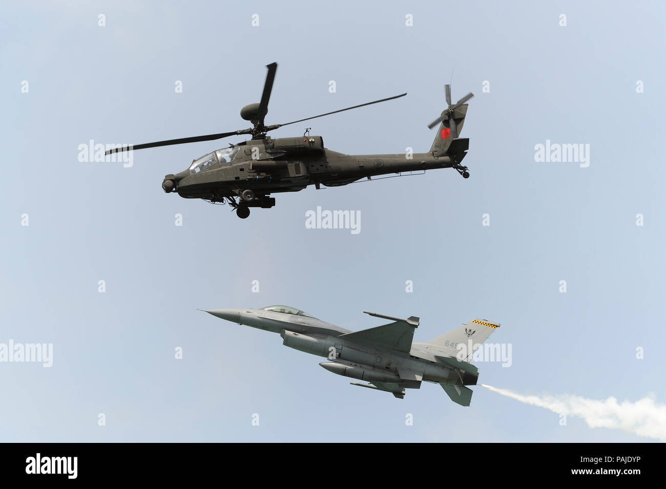 Singapore Air Force RSAF Boeing AH-64D Apache e Lockheed Martin F-16C Fighting Falcon con emissione di fumo bianco in flying-display in Singapore-Airsho Foto Stock