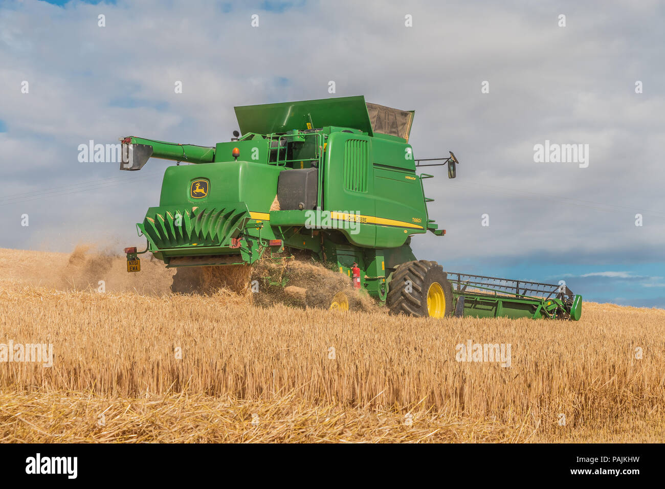 Agricoltura del Regno Unito, John Deere mietitrebbia Hillmaster durante il lavoro su un inverno di raccolto di orzo Foto Stock