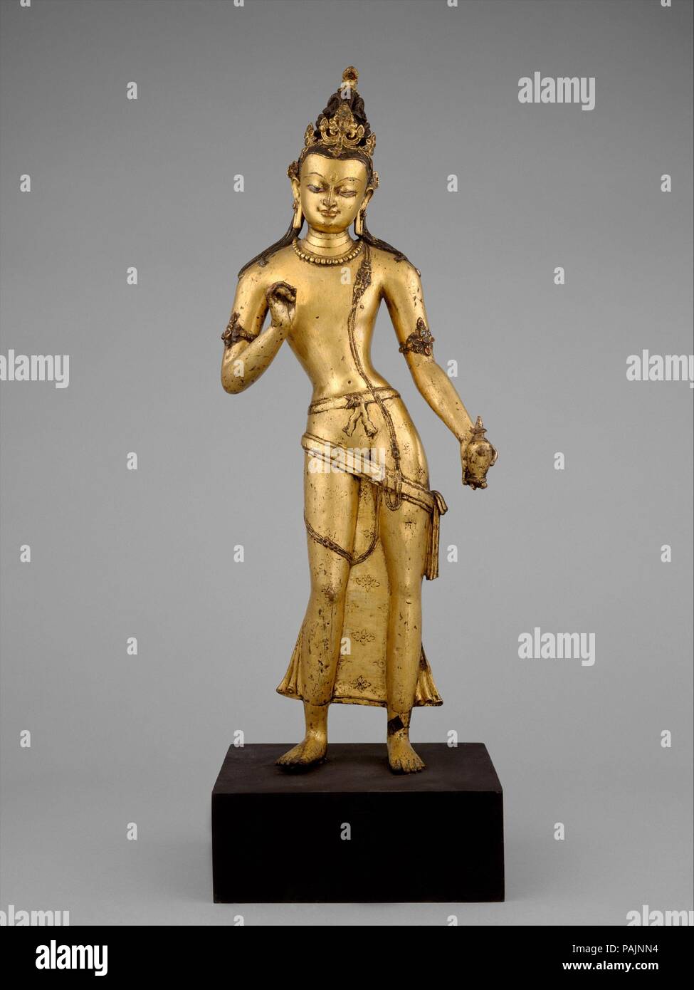 Il Bodhisattva Maitreya, il Buddha del futuro. Cultura: il Nepal. Dimensioni: H. 26 a. (66 cm); W. 8 1/4 in. (20,9 cm). Data: XI secolo. Maitreya, il Bodhisattva messianica caratterizzato come il Buddha del futuro, sorge in un cortesemente esagerata la postura, il corpo splendidamente controbilanciato. Egli trattiene la sua mano alzata nel gesto di esposizione (vitarka mudra) e nella sua mano abbassata visualizza un pallone (kamandalu) universalmente inteso nel Sud Est asiatico la cultura come il contenitore di amrta, l'elisir di lunga vita. In una impostazione buddista, il pallone viene inteso come la promessa di Maitreya com Foto Stock