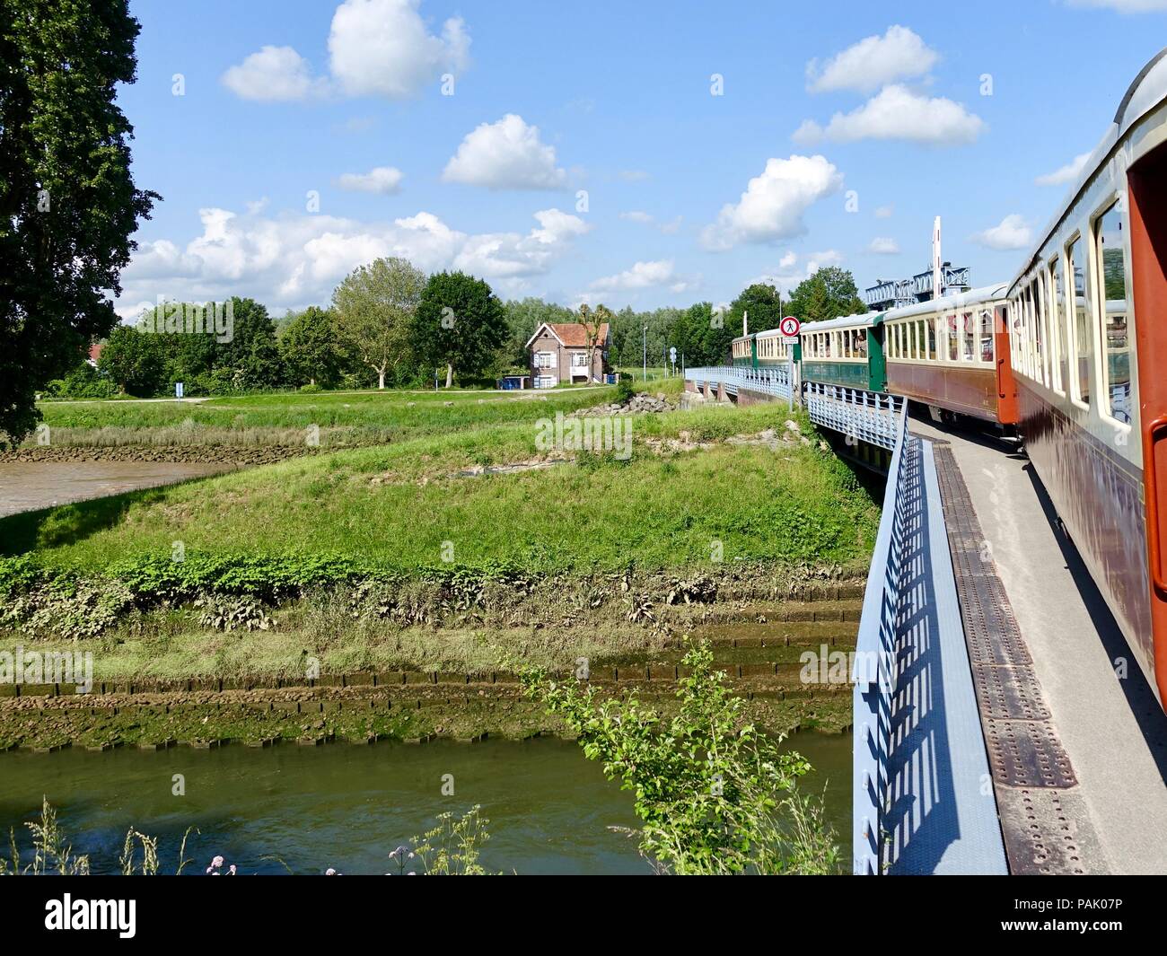 Le Chemin de Fer, Baie de Somme, treno con locomotiva a vapore, attraversando un ponte come esso si discosta Saint-Valery-sur-Somme, Francia. Foto Stock