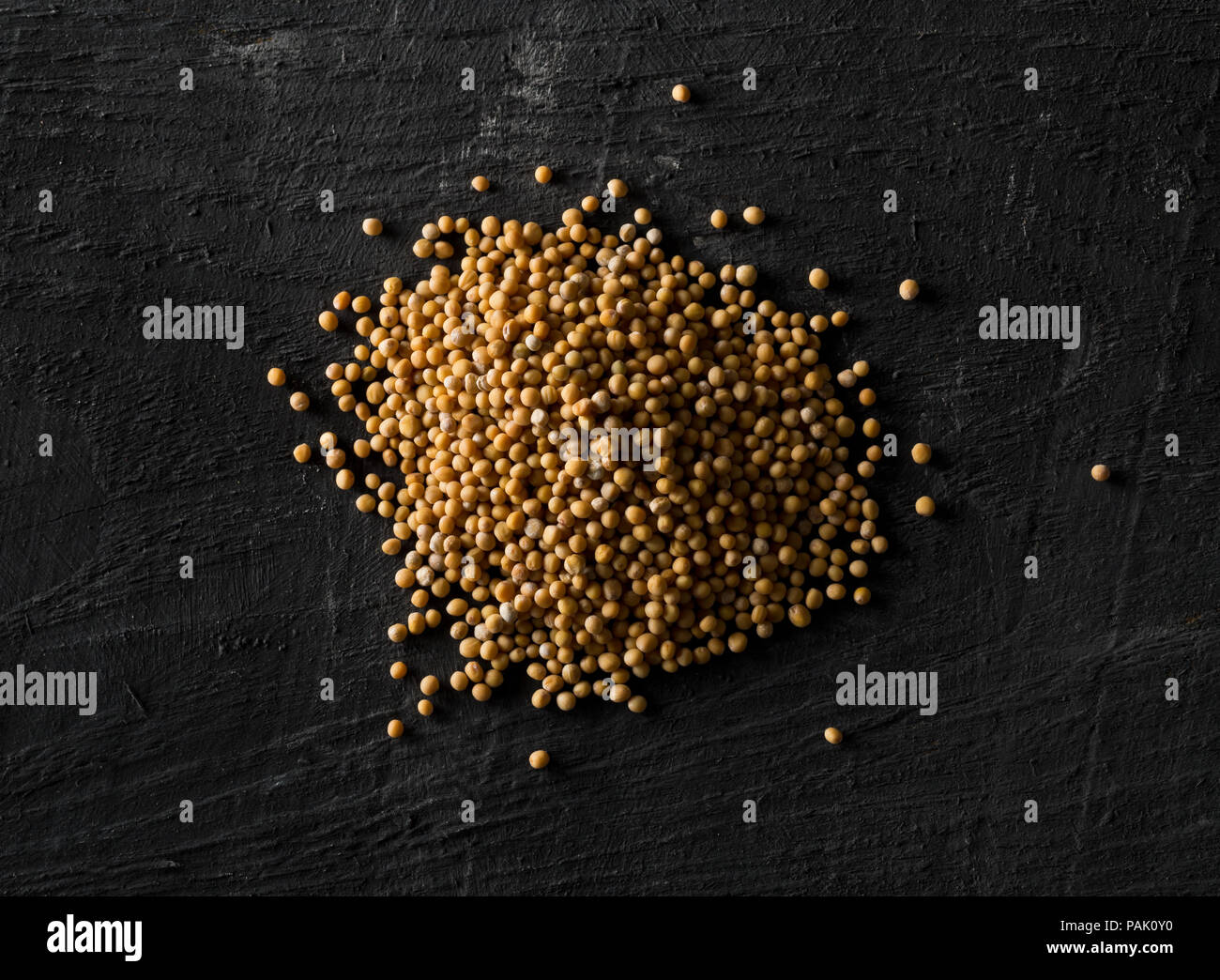 Cumulo di materie, non trasformati seme di senape Semi sul nero lo sfondo della tabella Foto Stock