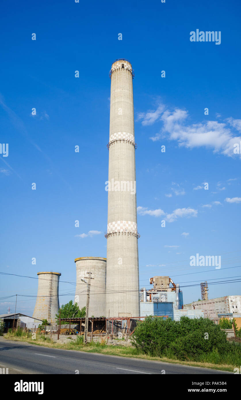 Vecchia fabbrica abbandonata forno in calcestruzzo con un alto statura sottile su un luminoso giorno suggerendo socialista comunista reliquie industriale Foto Stock