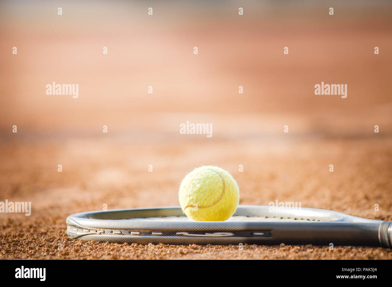 Palla da tennis su una racchetta in presenza di luce diretta del sole con un aspetto drammatico suggerendo tennis enlinghtment e talento Foto Stock
