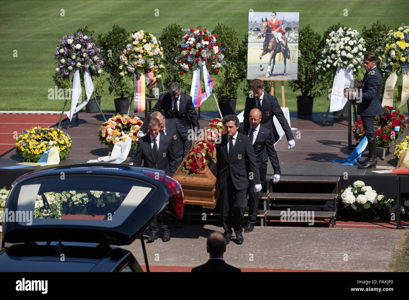 Warendorf, Germania. Il 24 luglio, 2018. Peter Teeuwen (L-R), Heinrich-Hermann Engemann, Otto Becker, nazionale show jumping allenatori e Soenke Lauterbach, Segretario generale tedesco del Comitato olimpico per sport equestri e.V. (DOKR), Eberhard Seemann e Dennis Peiler, Amministratori Delegati tedesco del Comitato olimpico per sport equestri e.V. (DOKR) (R), portano la bara del late show ponticello Guenter Hans Winkler. Eventing rider Andreas Ostholt (R) è guardare. Winkler era morto in Warendorf il 9 luglio 2018. Credito: Friso Gentsch/dpa/Alamy Live News Foto Stock