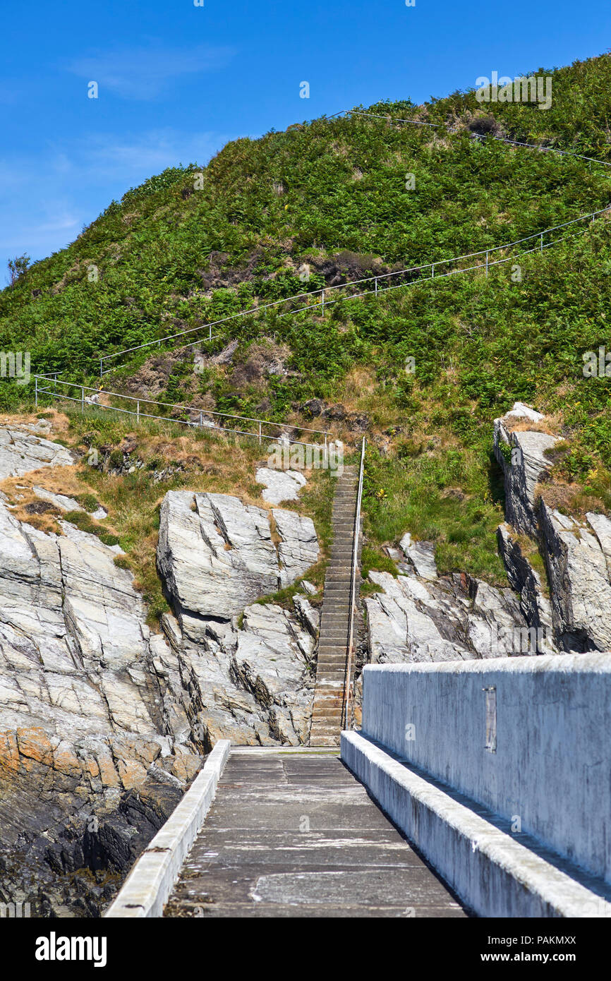 Passi che conducono fino alla scogliera di fronte dal porto esterno muro a Laxey, Isola di Man Foto Stock