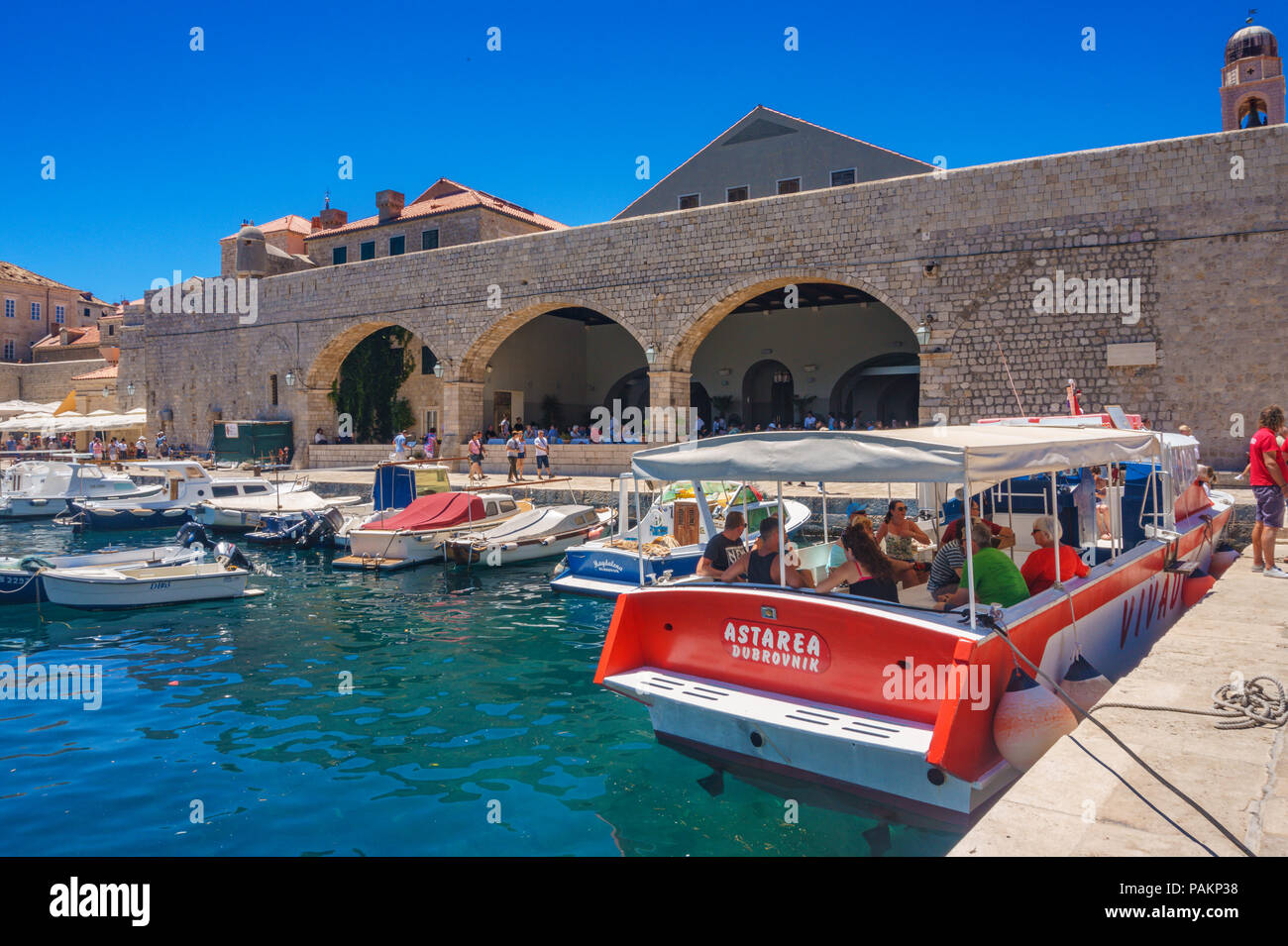 Vista panoramica con i turisti in una crociera in barca presso il porto antico di Dubrovnik, Croazia. Centrata la famosa fortezza di Dubrovnik. Croazia, mare Adriatico. Foto Stock