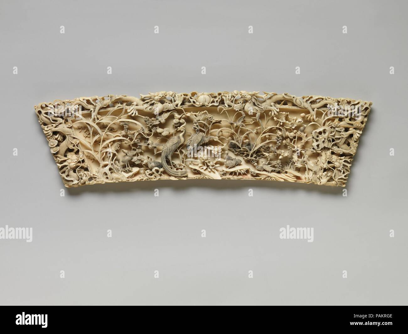 Placca con Dragon, fagiani, quaglie e altri uccelli nel mezzo di bambù e prugna Fiore. Cultura: la Cina. Dimensioni: H. 6 1/8 in. (15,6 cm); W. 21 1/4 in. (54 cm); D. 7/8 in. (2.2Cm). Data: fine del XIX secolo. Nonostante il marchio Qianlong (1736-95) incisa sul retro di questa placca, caratteristiche stilistiche, come ad esempio il Dragon's grandi corna e goffamente resi artigli, indicano che questo oggetto è stato prodotto più tardi, possibilmente per l'esportazione. Essa è decorata con un paesaggio inciso sul retro. Museo: Metropolitan Museum of Art di New York, Stati Uniti d'America. Foto Stock