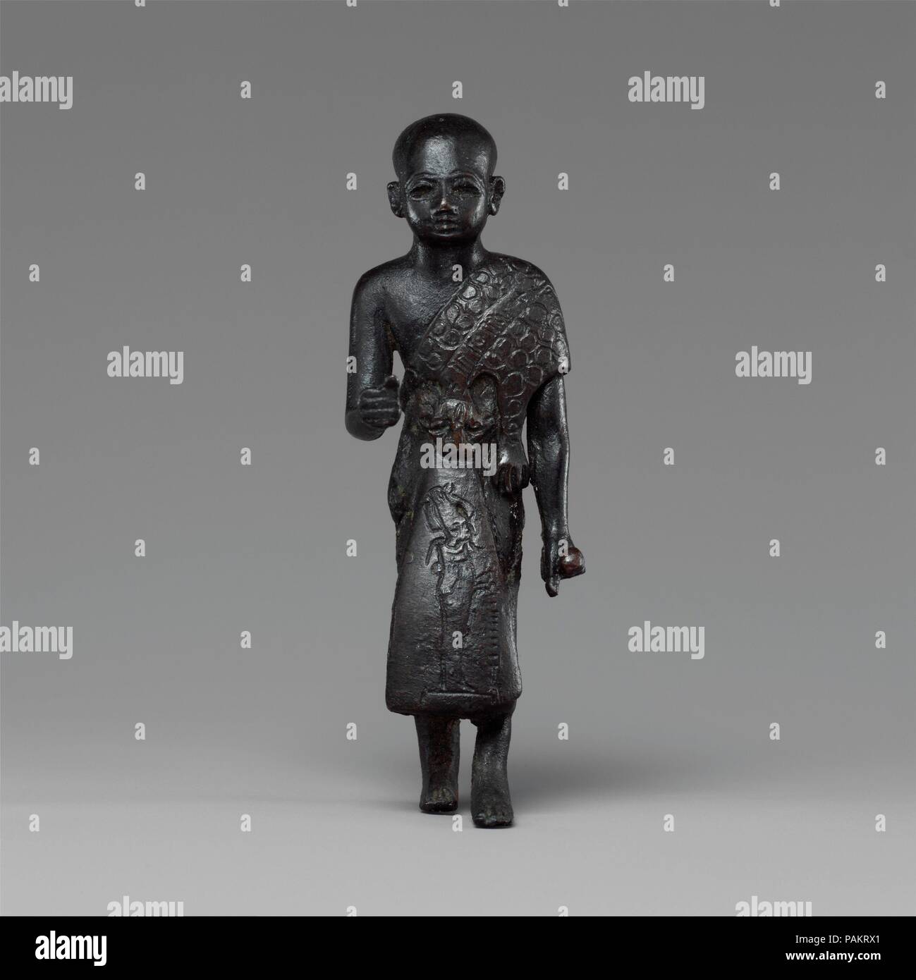 Un sacerdote in pelle di leopardo mantello con una iscrizione e Osiride sul suo mantello. Dimensioni: H. 8.6 × W. 3 × D. 3 cm (3 3/8 × 1 3/16 x 1 3/16 in.); H (con tenone): 9,3 cm (3 11/16 in.). Dynasty: Dynasty 25. Data: ca. 712-664 A.C. Al di sopra della pelle di leopardo questo uomo indossa è un banderole inscritto con i resti del suo nome e titolo: " Dio il Padre, gli amati di Dio, . . .Haty. . . ." È stato suggerito che la presenza dei titoli e nomi dei soggetti piuttosto che il re può essere caratteristico della Kushite o molto precoce periodo Saite. Se vero, questo sarebbe d'accordo con la caratteristica stilistica Foto Stock